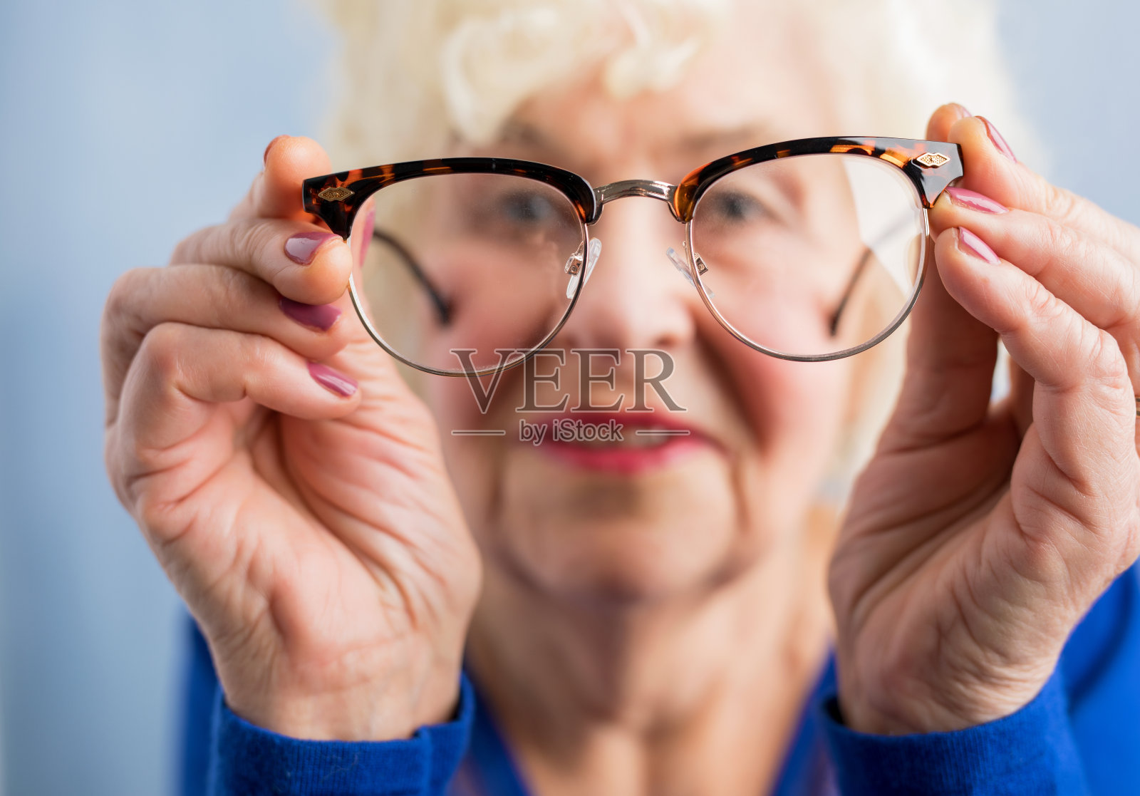 老妇人透过眼镜看东西照片摄影图片