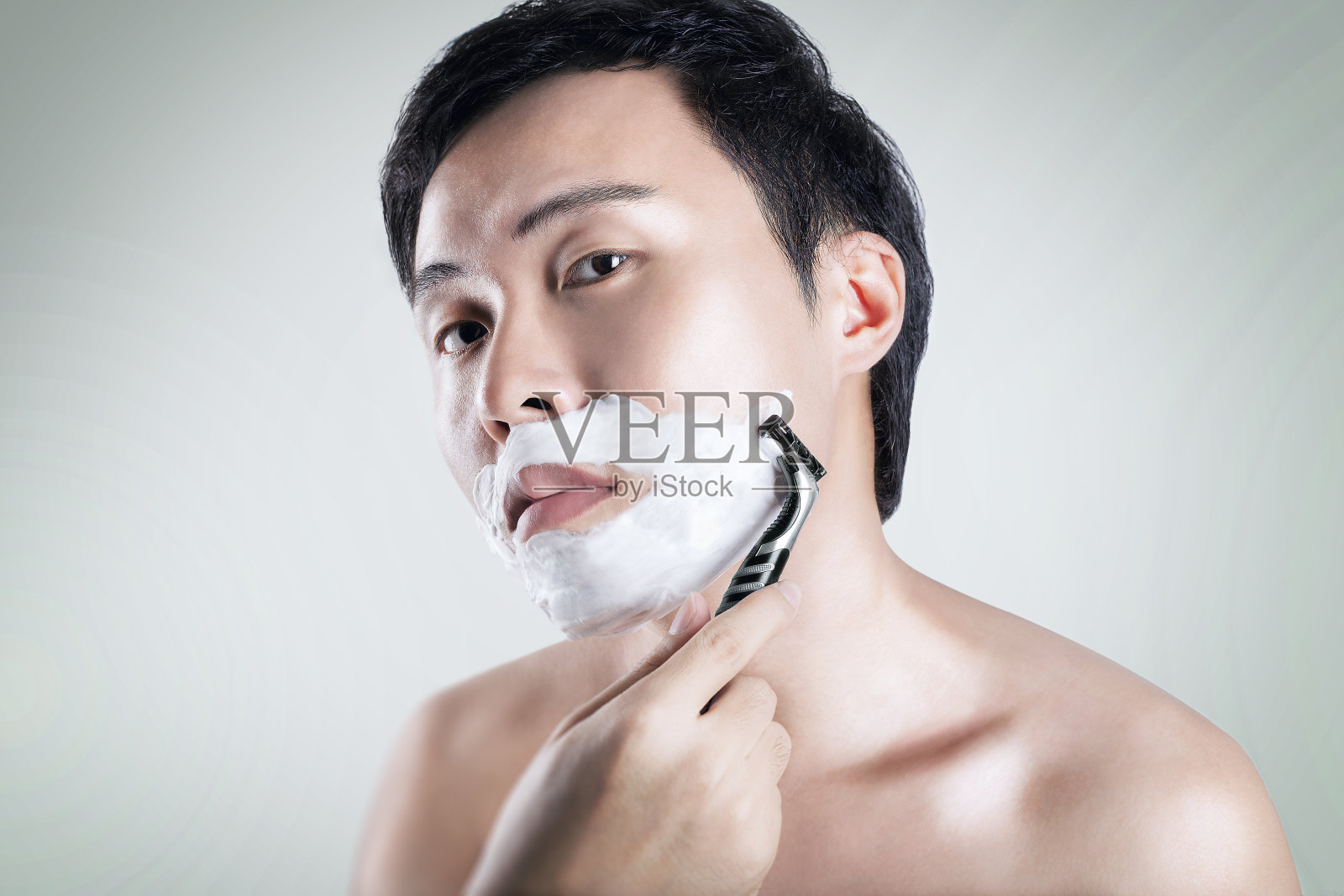 亚洲男人正在刮胡子照片摄影图片
