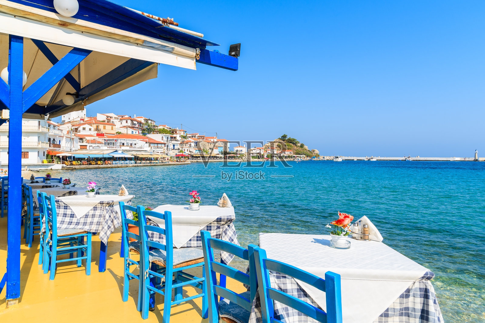 希腊萨摩斯岛海岸Kokkari镇的传统希腊酒馆里的桌子和椅子照片摄影图片