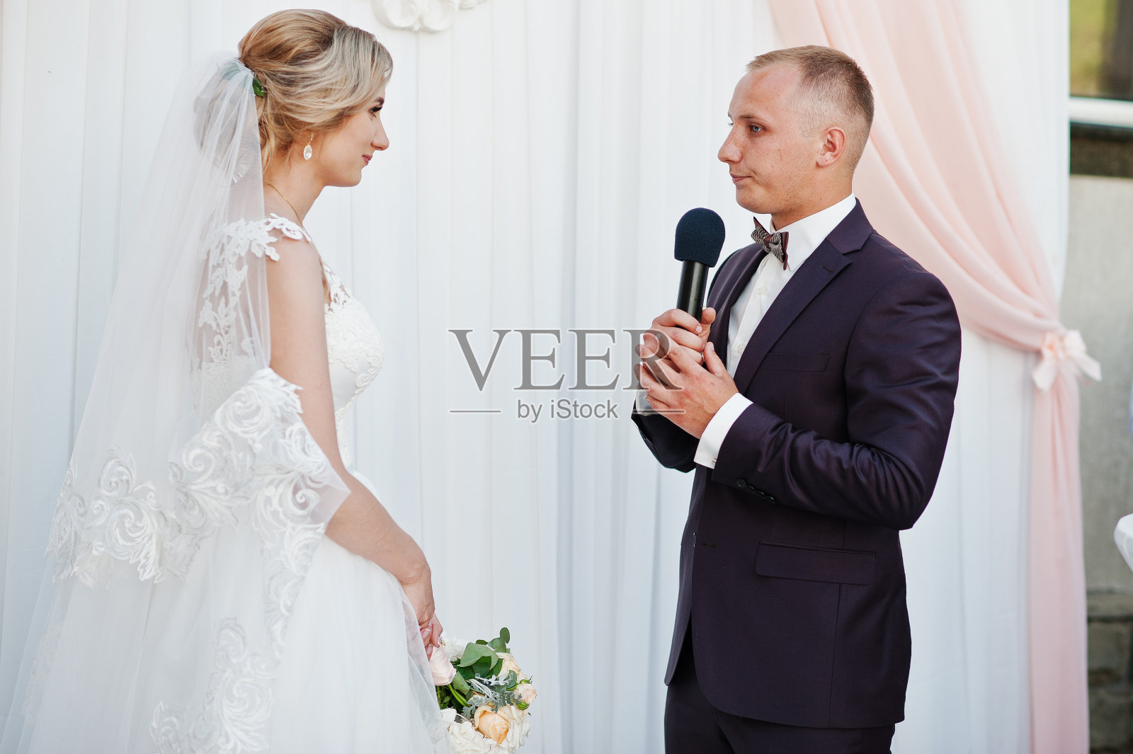 新郎致辞，在婚礼上对着麦克风为新娘讲话。照片摄影图片