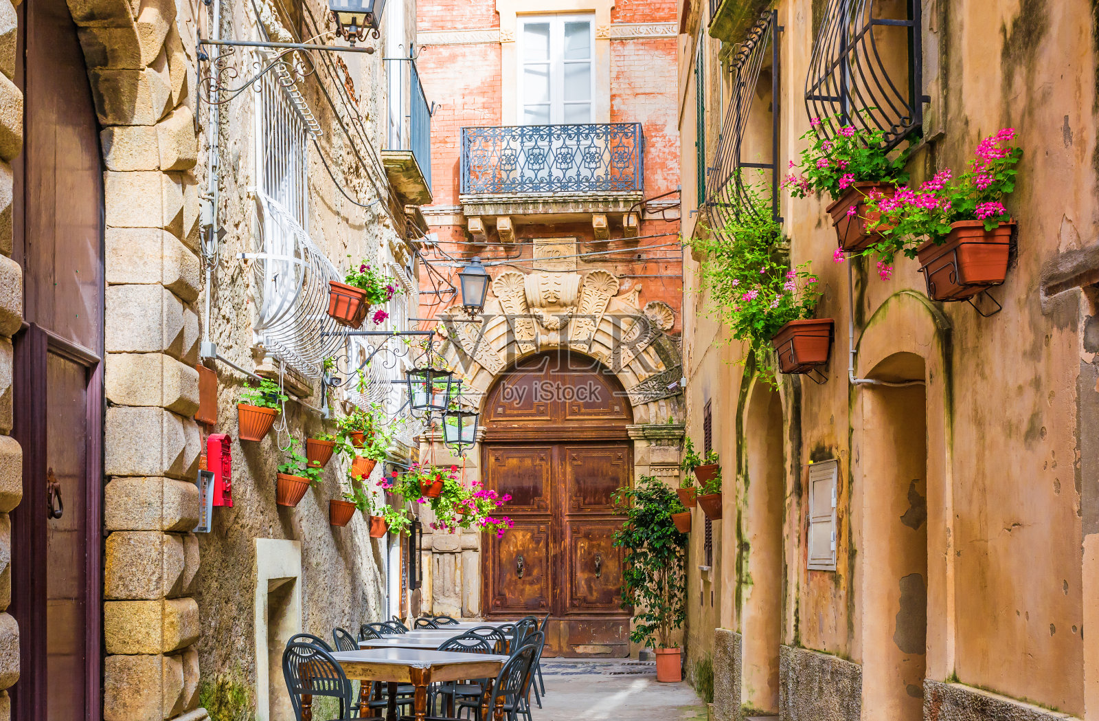 意大利波西塔诺镇的一条古老舒适的街道上，咖啡馆的桌椅照片摄影图片