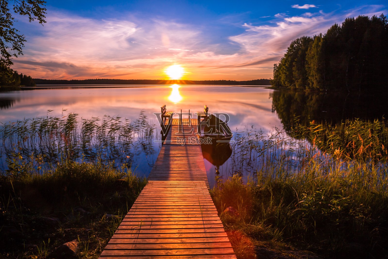 夕阳在芬兰湖边的钓鱼码头上照片摄影图片