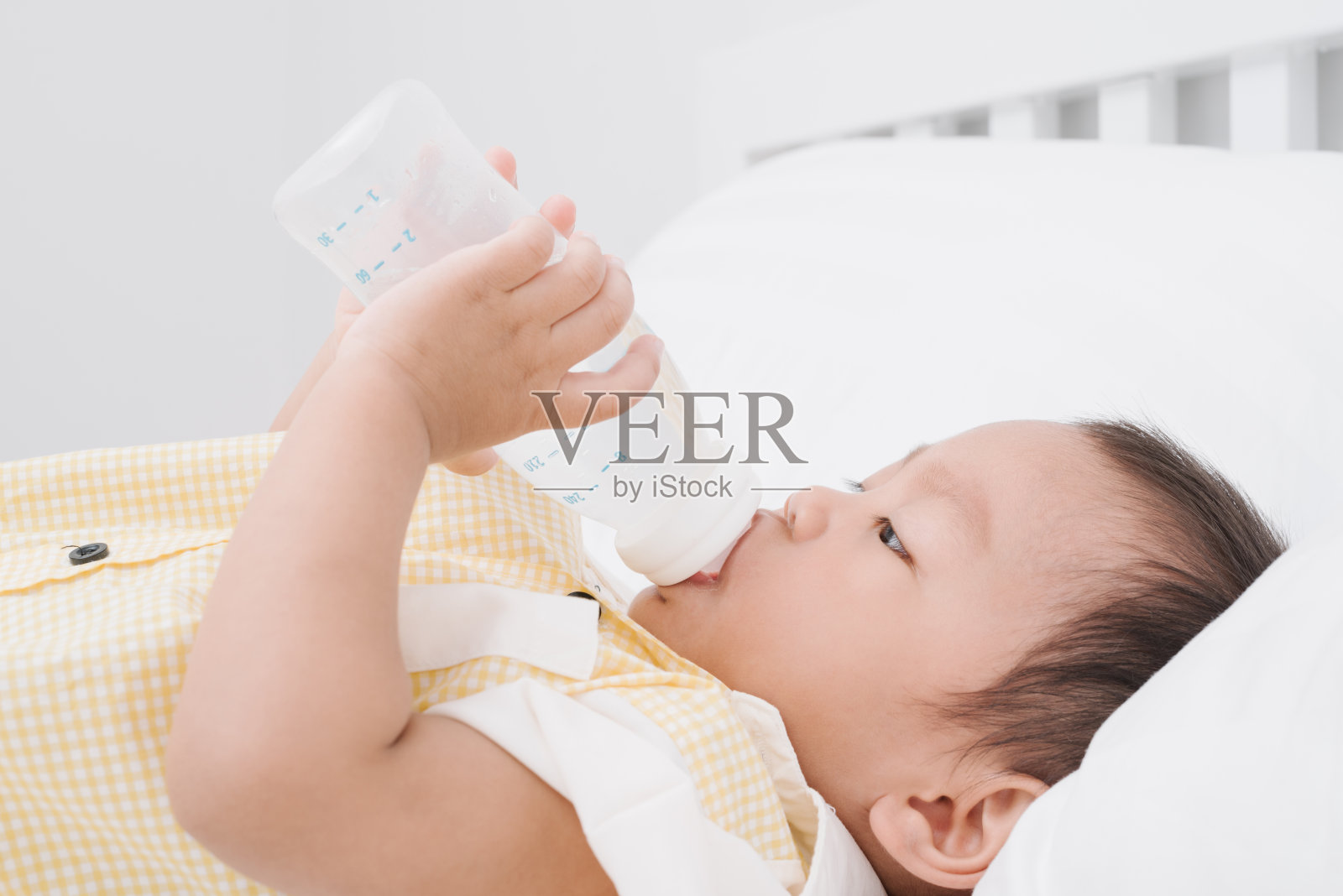 婴儿用奶瓶喝牛奶照片摄影图片