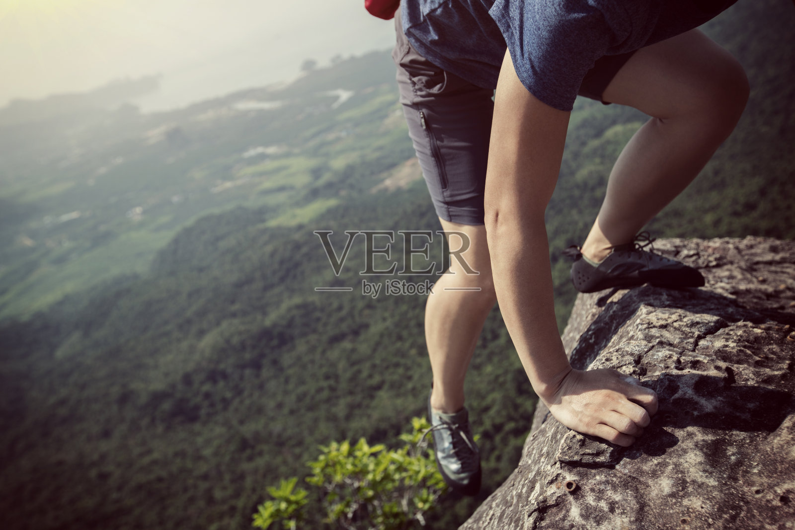 成功的年轻女子攀岩者在山顶照片摄影图片