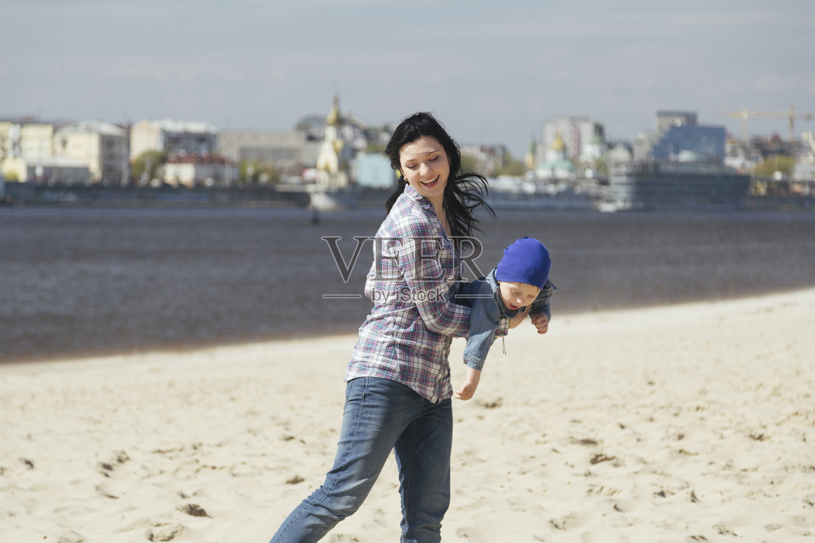 幸福的年轻家庭在海滩上玩日落照片摄影图片