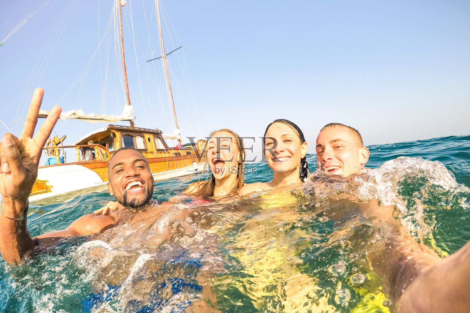 年轻的多种族朋友在帆船海上旅行自拍和游泳-富有快乐的男孩和女孩在夏日派对日的乐趣-独家度假概念-明亮的下午温暖的过滤器照片摄影图片