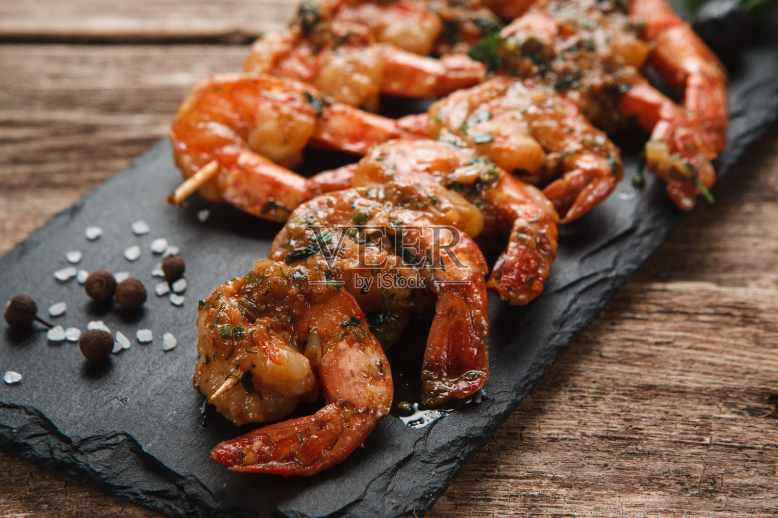 黑石板上的烤虾。地中海食物。照片摄影图片