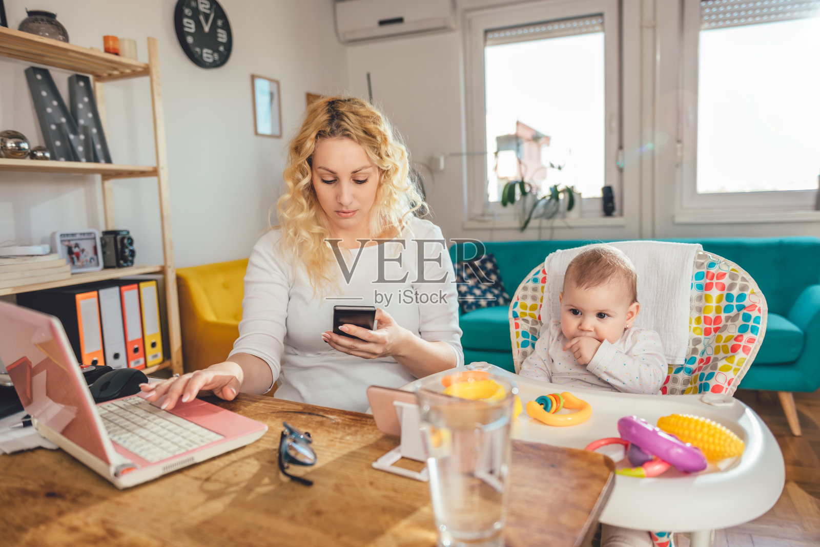 母亲使用智能手机在家办公和她的孩子照片摄影图片