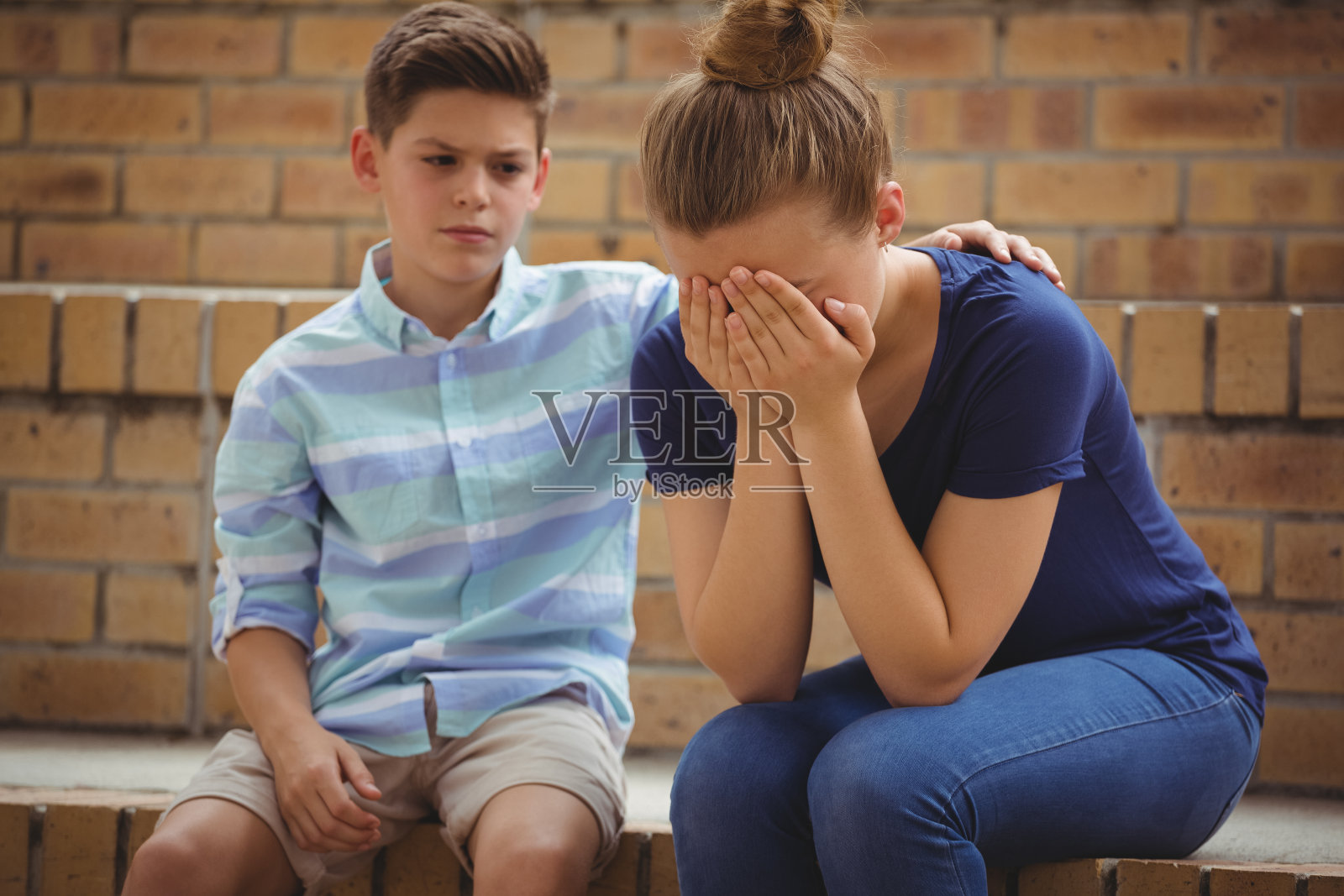 一个男生在校园里台阶上安慰她伤心的朋友照片摄影图片