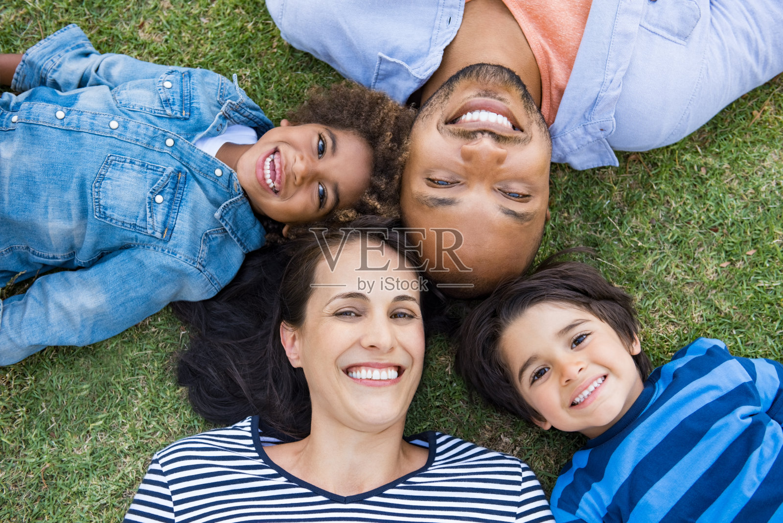 一家人躺在草地上照片摄影图片