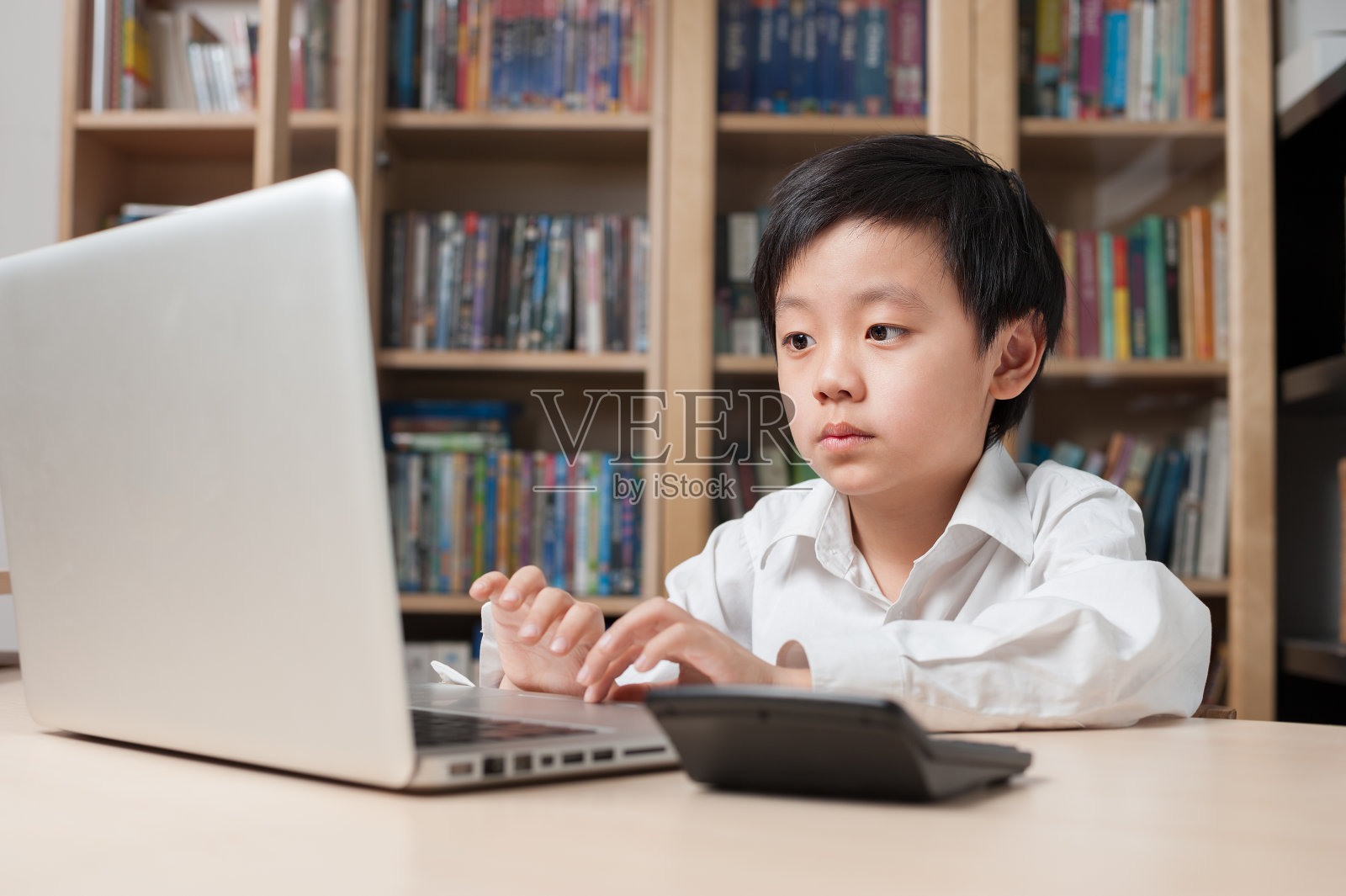 亚洲男孩坐在笔记本电脑前照片摄影图片