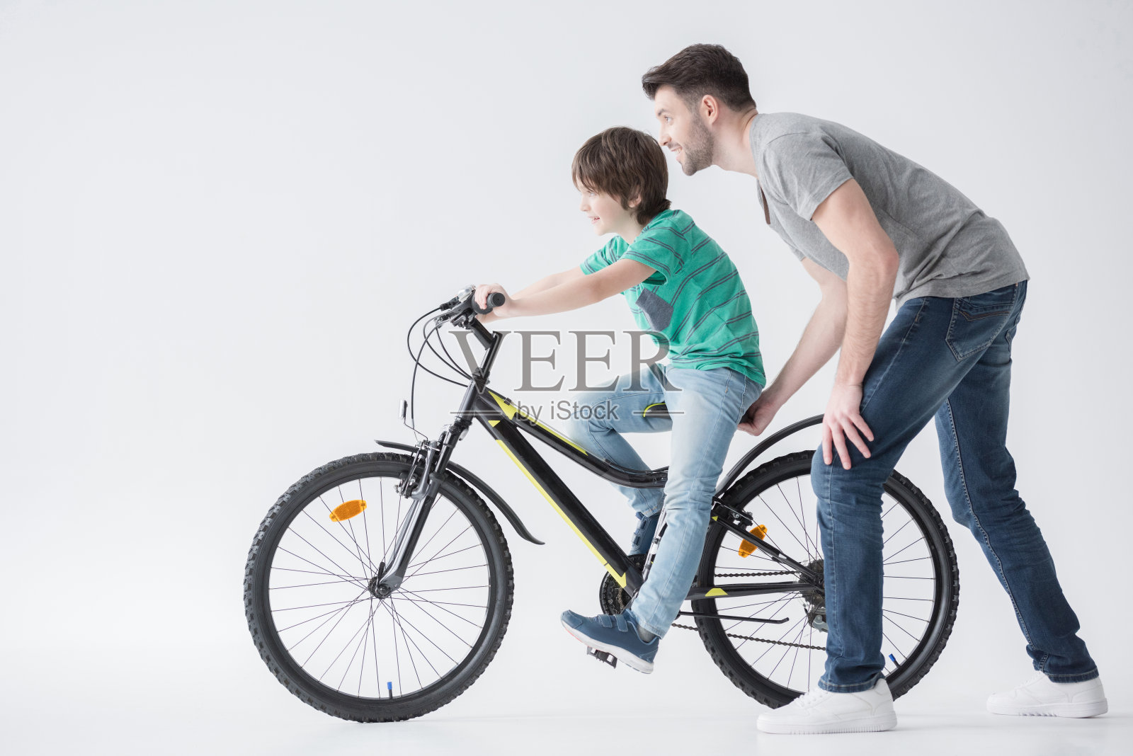 爸爸帮儿子骑自行车照片摄影图片
