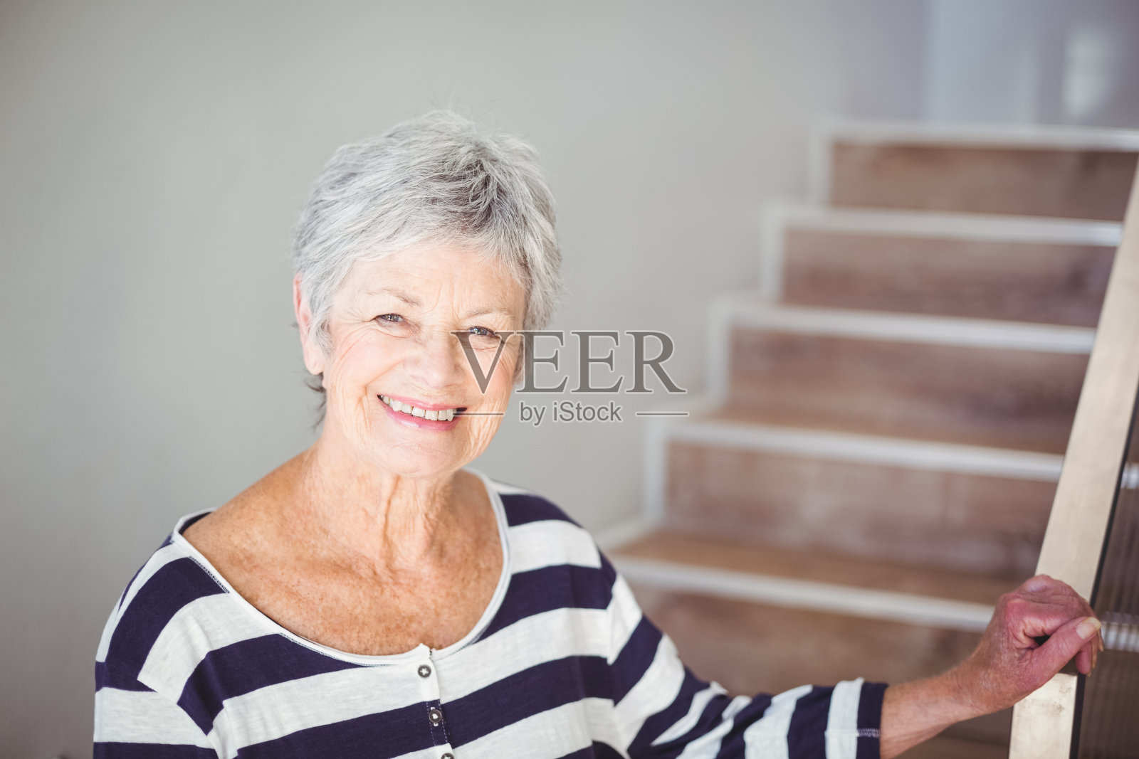 楼梯旁快乐的老妇人的肖像照片摄影图片