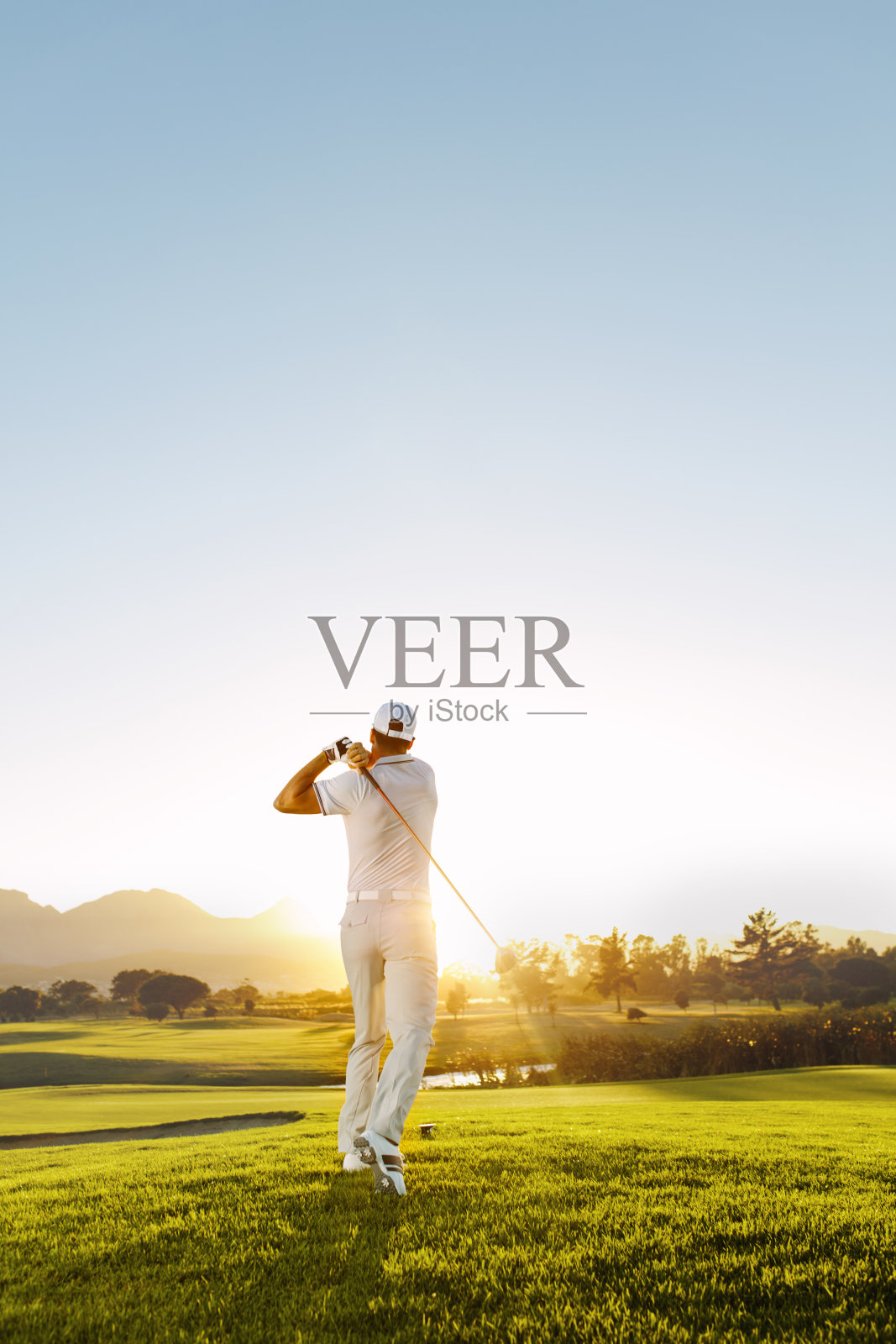 一个年轻人在一个阳光明媚的日子打高尔夫球照片摄影图片