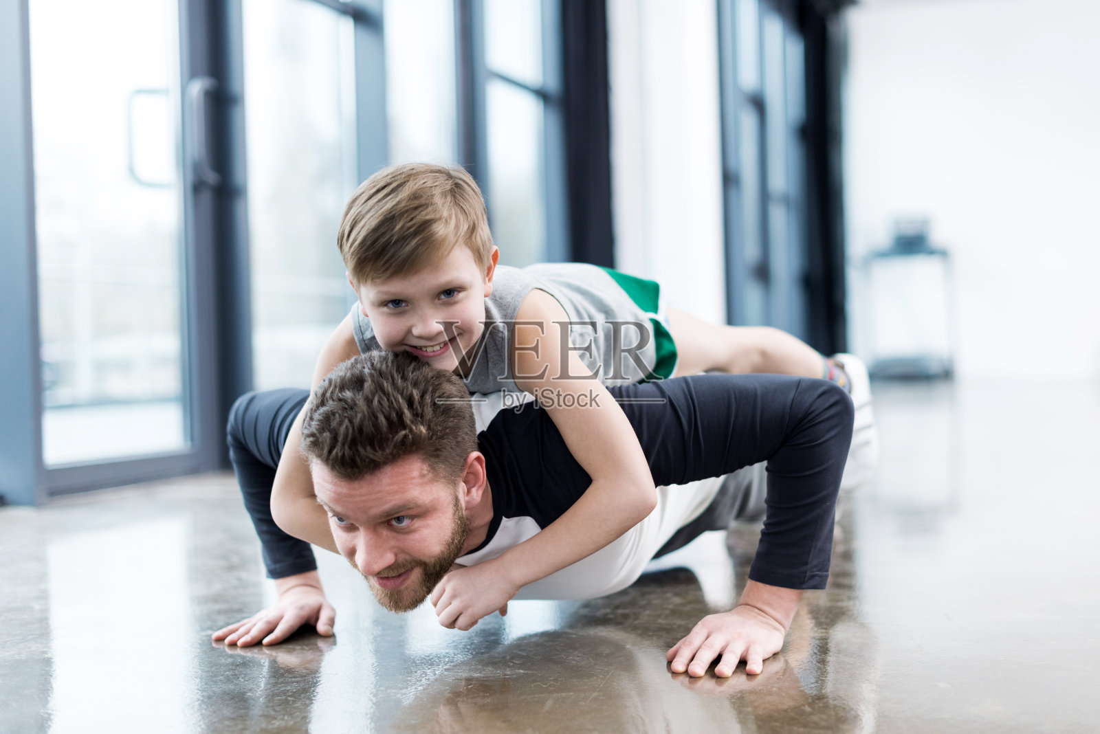一个男人背着一个男孩做俯卧撑照片摄影图片