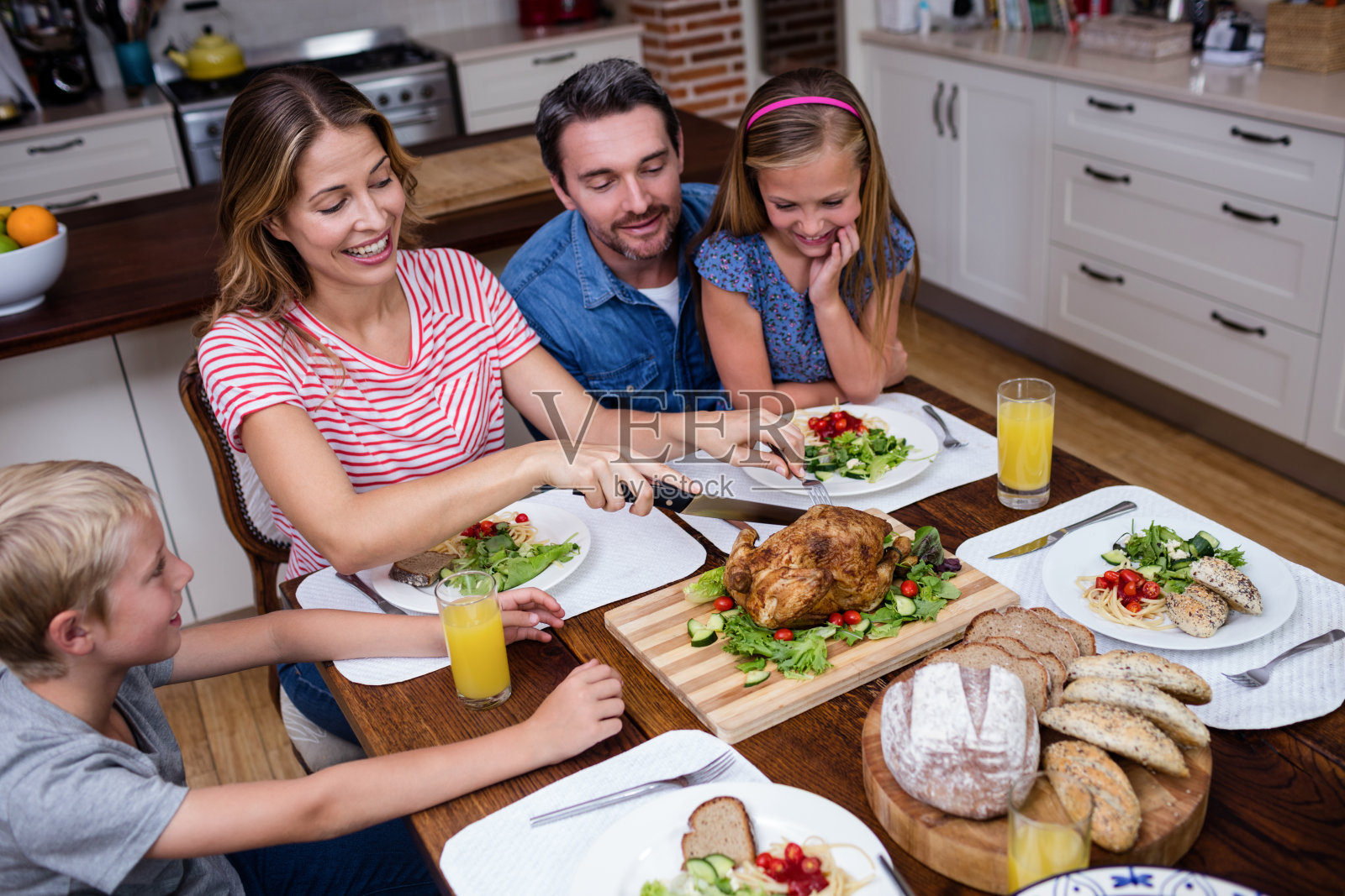 在和他的家人吃饭时，一个女人正在切烤火鸡照片摄影图片