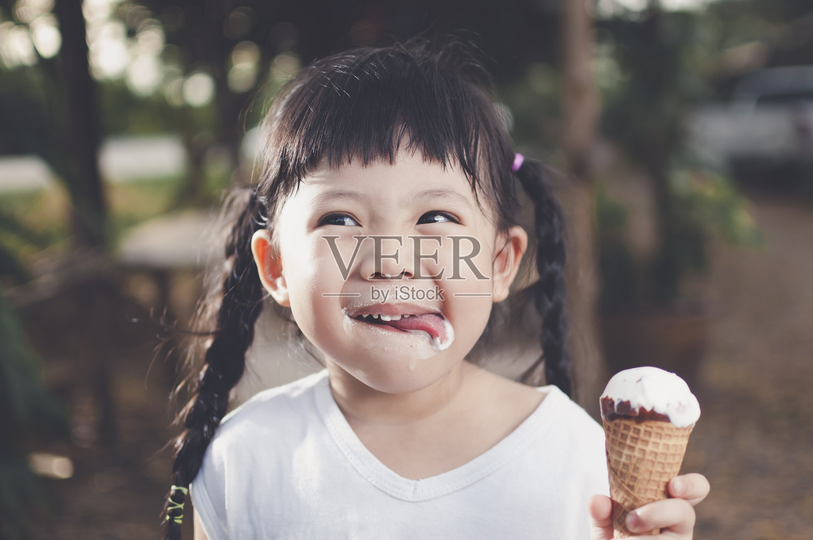 亚洲女孩吃冰淇淋。照片摄影图片