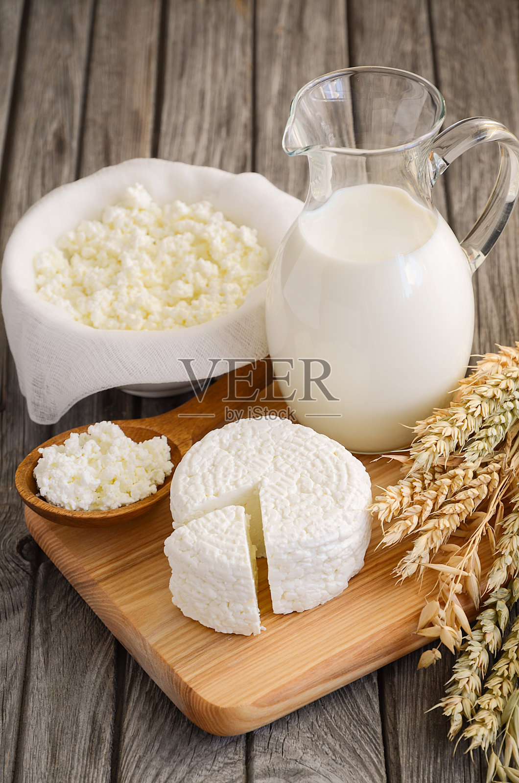 新鲜乳制品。牛奶和白软干酪的木制背景。照片摄影图片