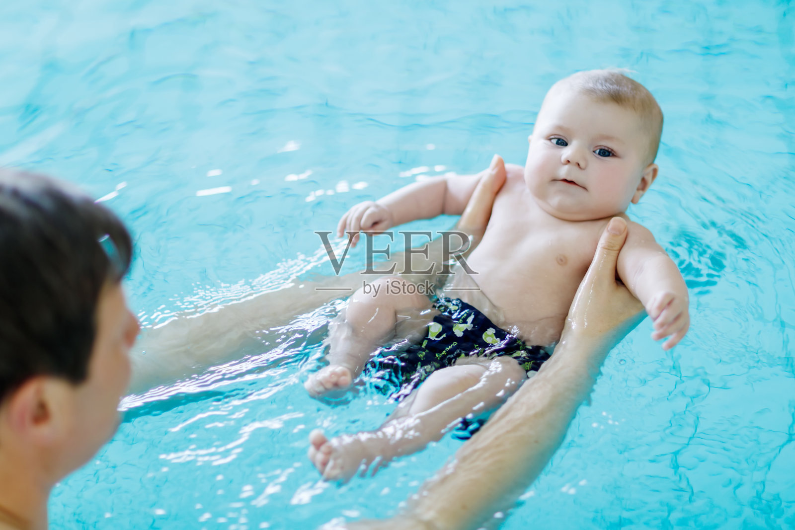 快乐的中年父亲和可爱的宝宝在游泳池游泳照片摄影图片