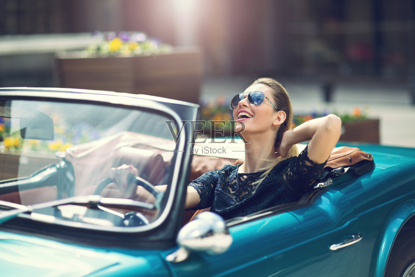 时尚女模特戴着太阳镜坐在豪华复古车里照片摄影图片