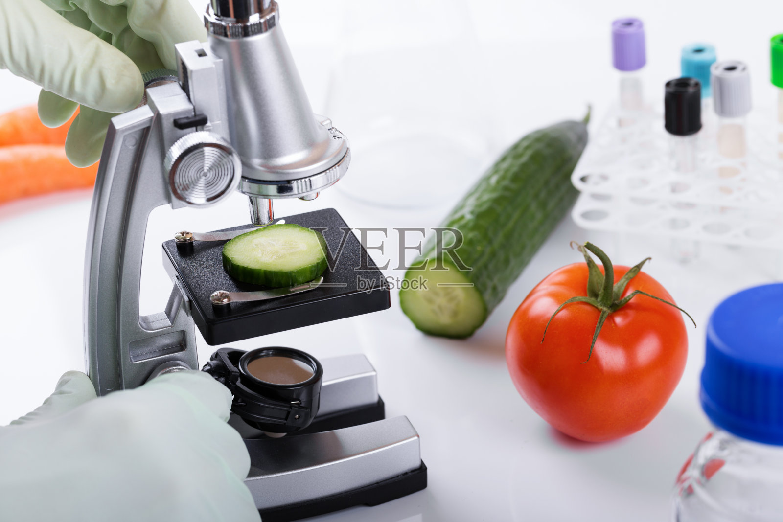 食品质量控制理念——科学家在实验室用显微镜检查黄瓜照片摄影图片