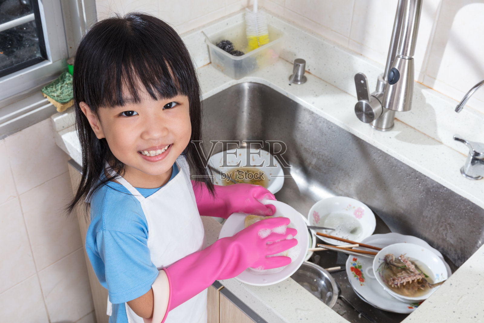 亚洲华人小女孩在厨房洗盘子照片摄影图片