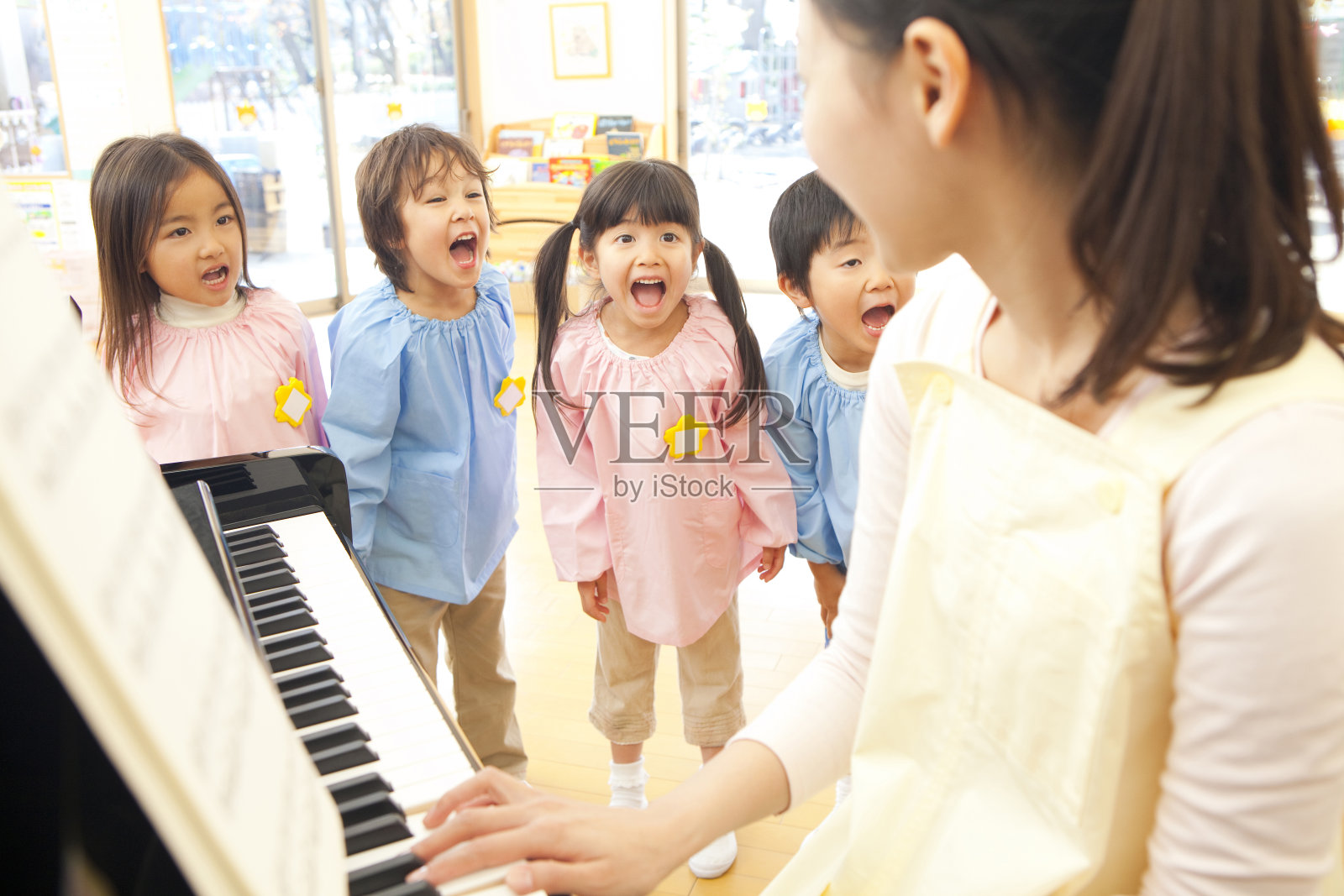 幼儿园的钢琴老师在幼儿园跟着唱照片摄影图片