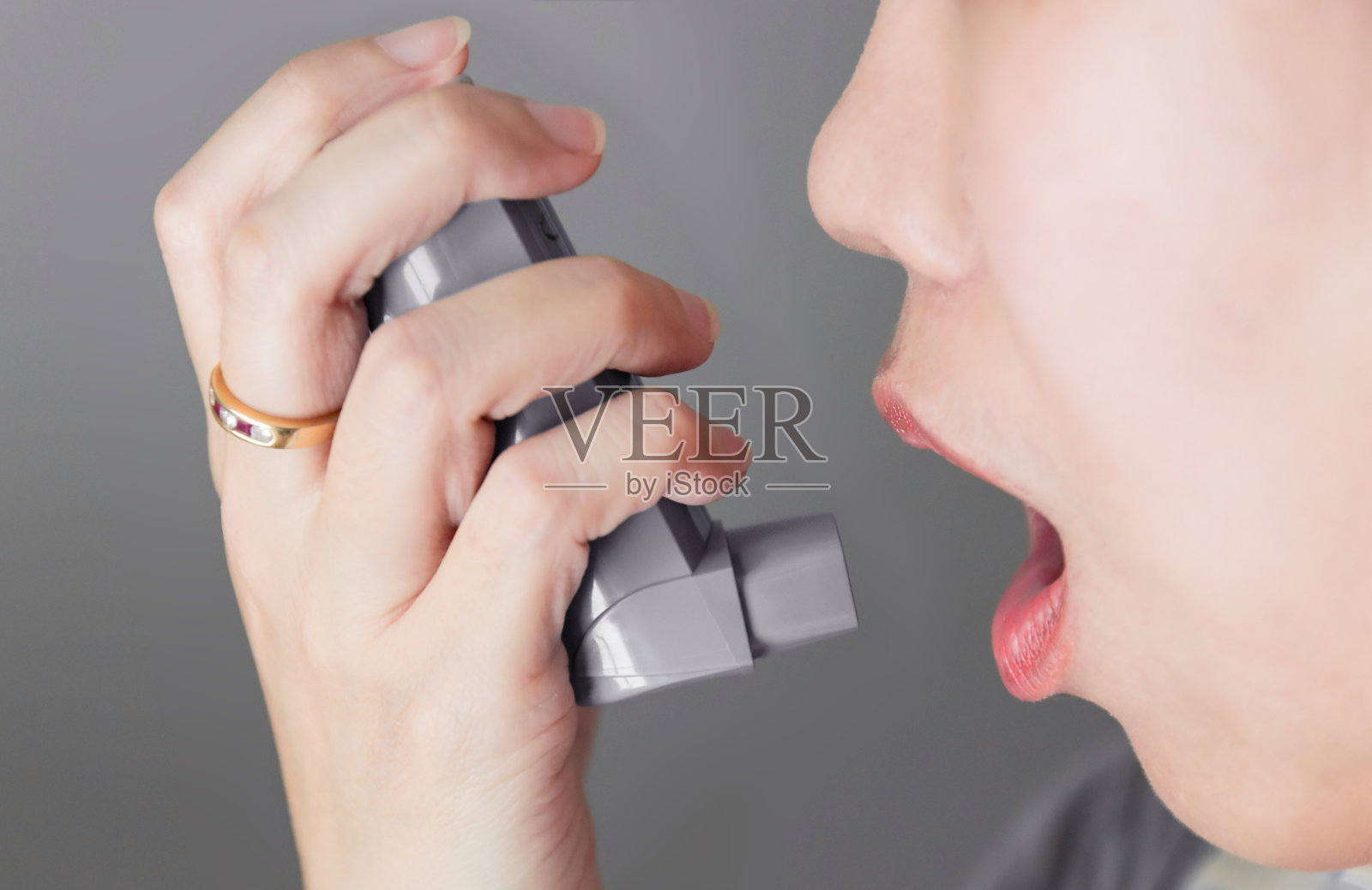 亚洲女性使用加压盒式吸入器延长咽部，支气管扩张器照片摄影图片