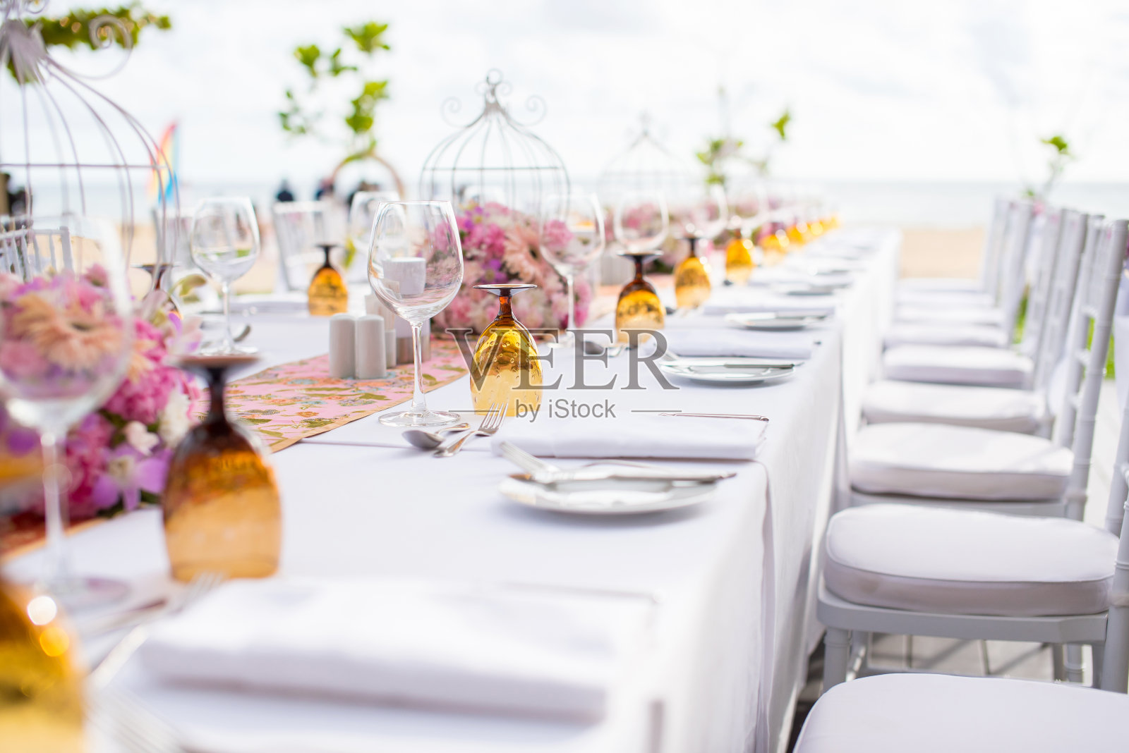 豪华婚礼的餐桌布置，桌上摆放着美丽的鲜花。照片摄影图片