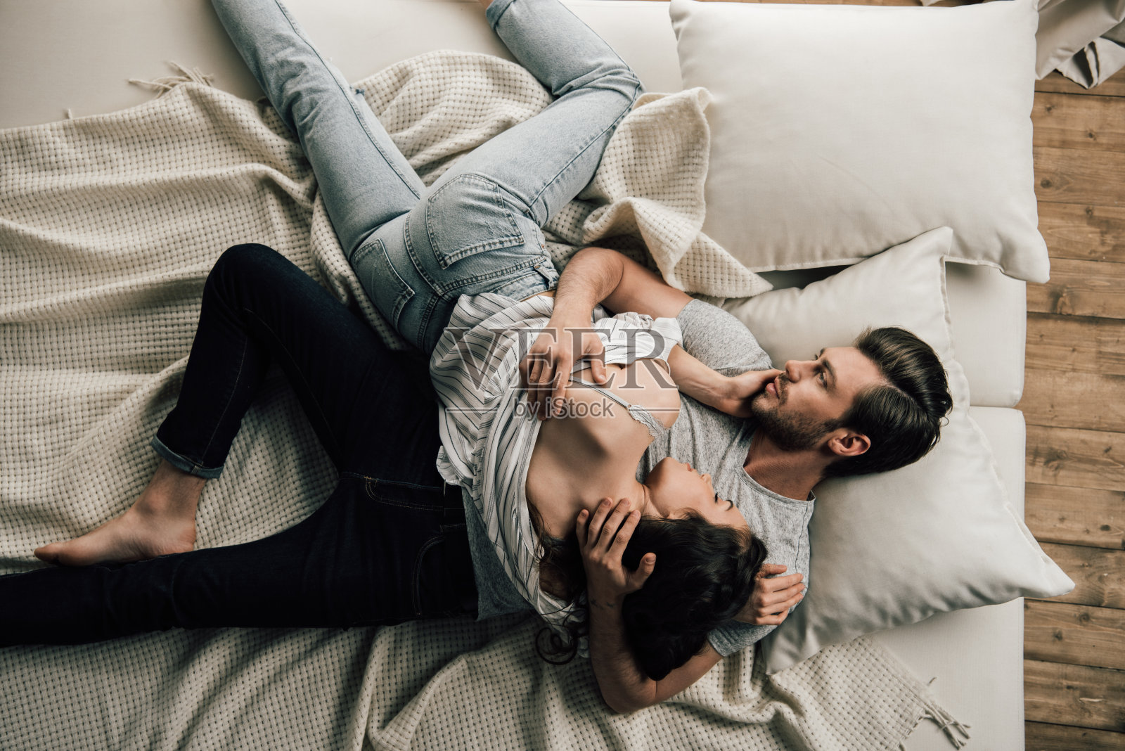 俯视图性感的年轻情侣躺在床上拥抱照片摄影图片