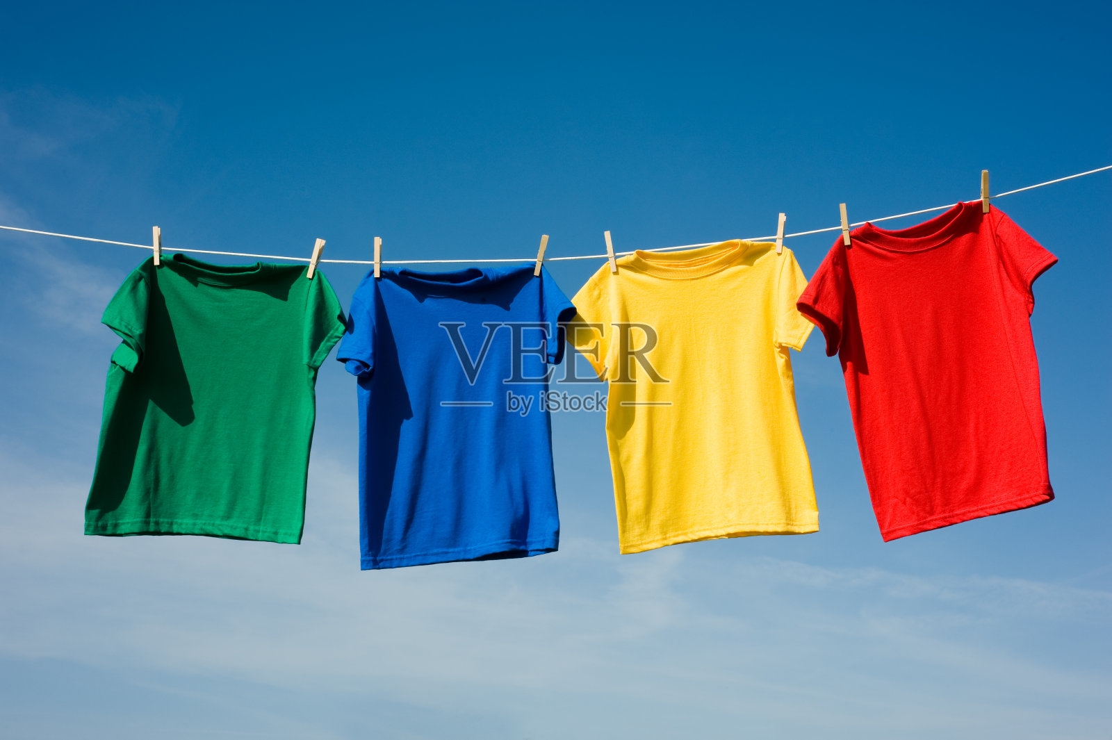 四件原色衬衫挂在晾衣绳上照片摄影图片