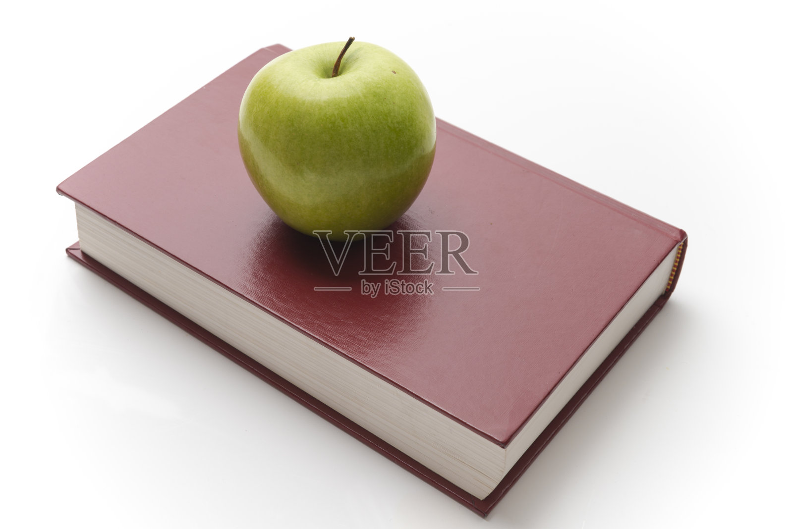 一个绿苹果在书上照片摄影图片