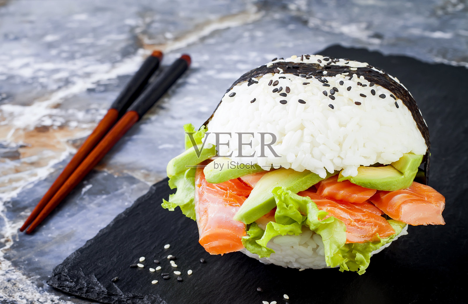 自制亚洲风味无面筋寿司三文鱼汉堡。Sushi-food混合动力车的趋势。明亮的蓝色背景与复制空间照片摄影图片