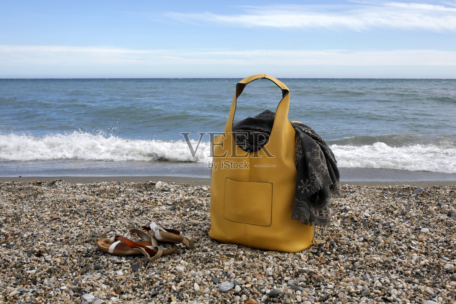 沙滩上的黄色皮包，围巾和凉鞋照片摄影图片