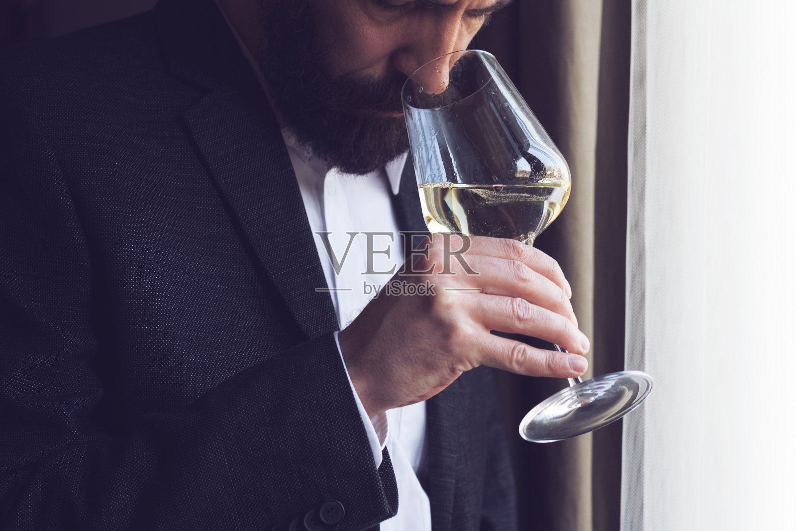 品尝一杯白葡萄酒的男人照片摄影图片
