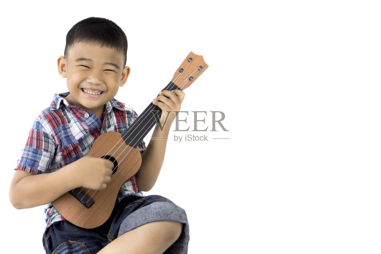 亚洲男孩弹吉他在孤立的白人背景照片摄影图片
