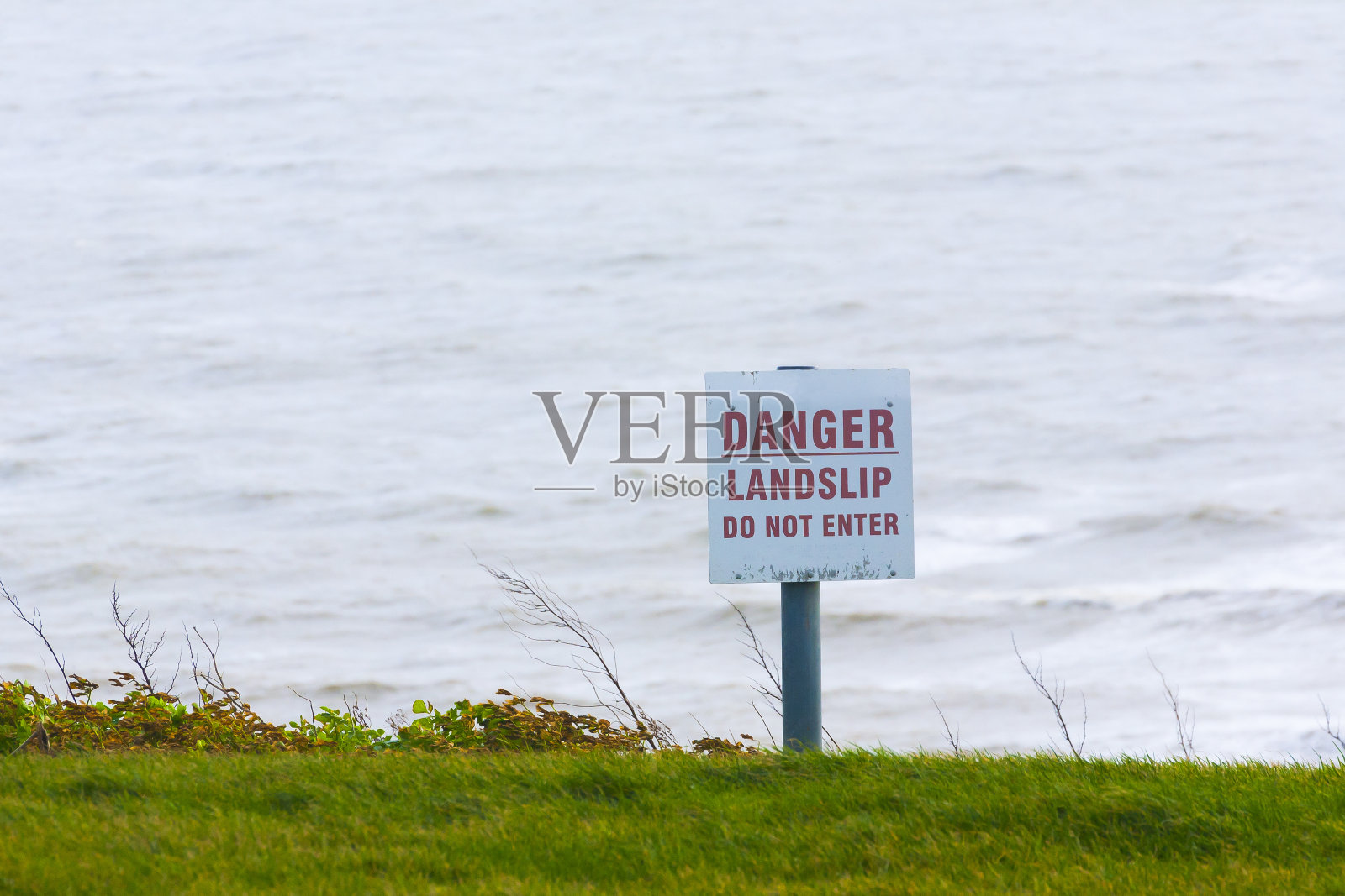 海崖旁的危险警示标志照片摄影图片