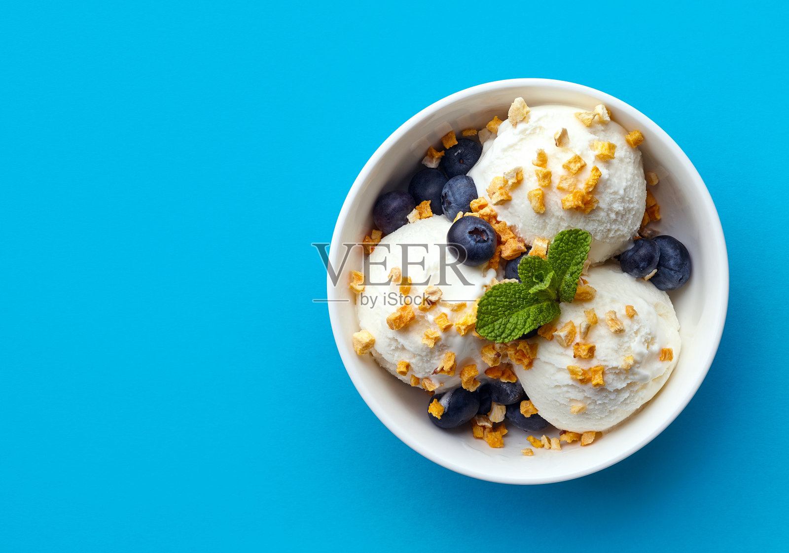 一碗香草冰淇淋，里面有蓝莓和芒果片照片摄影图片
