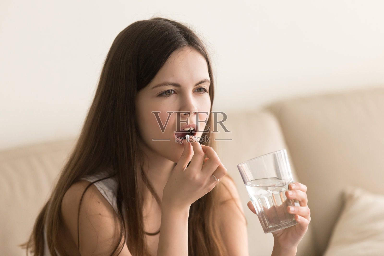 十几岁的女孩用一杯水喝药照片摄影图片