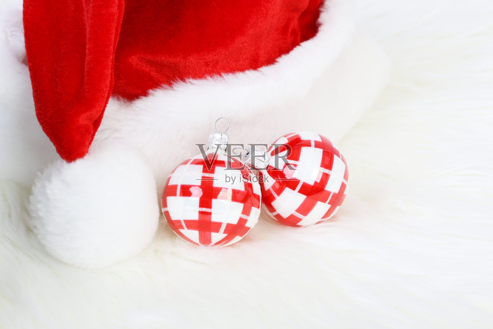 圣诞老人的帽子和两个红白相间的圣诞球照片摄影图片