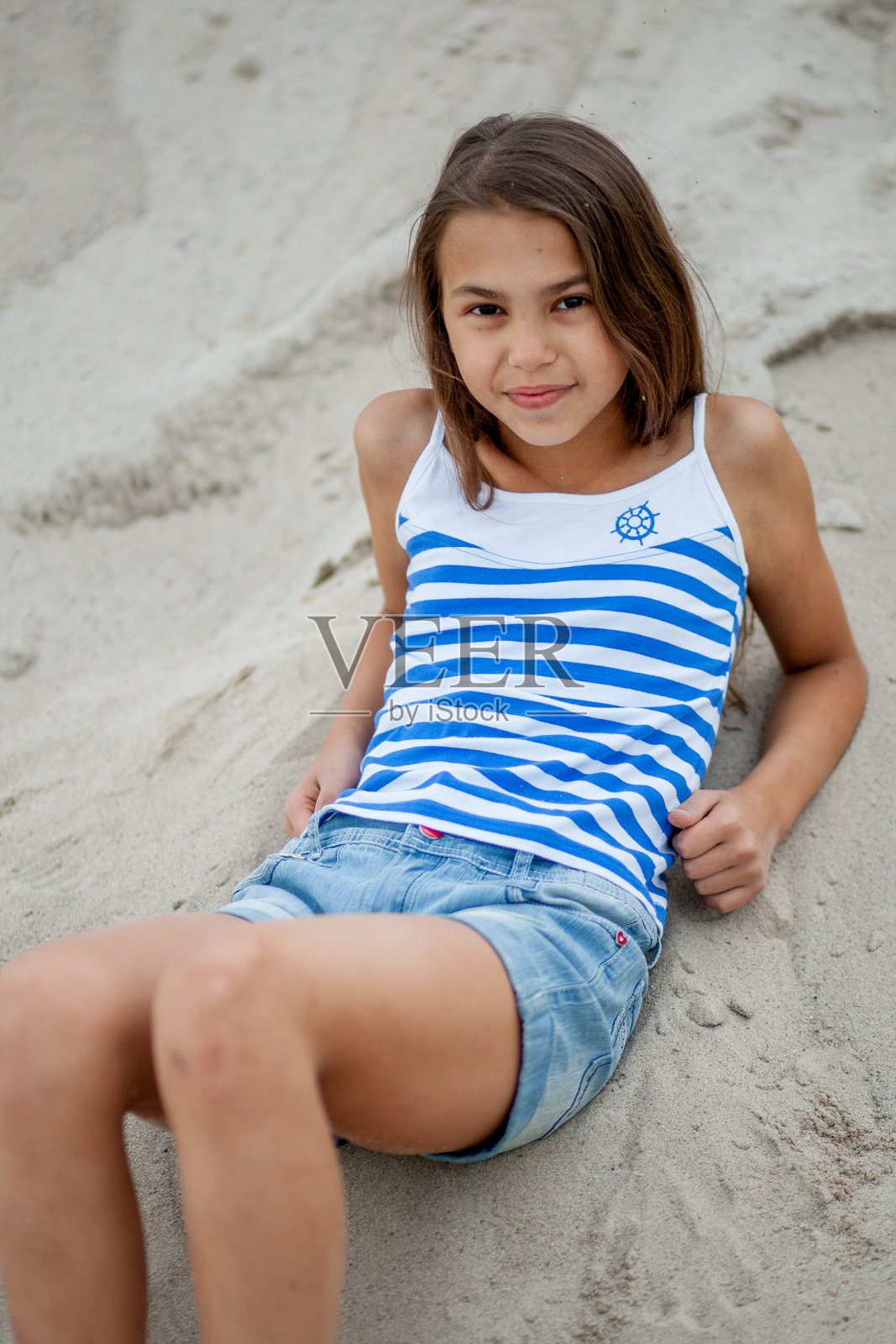 沙滩上穿着条纹背心的女孩照片摄影图片