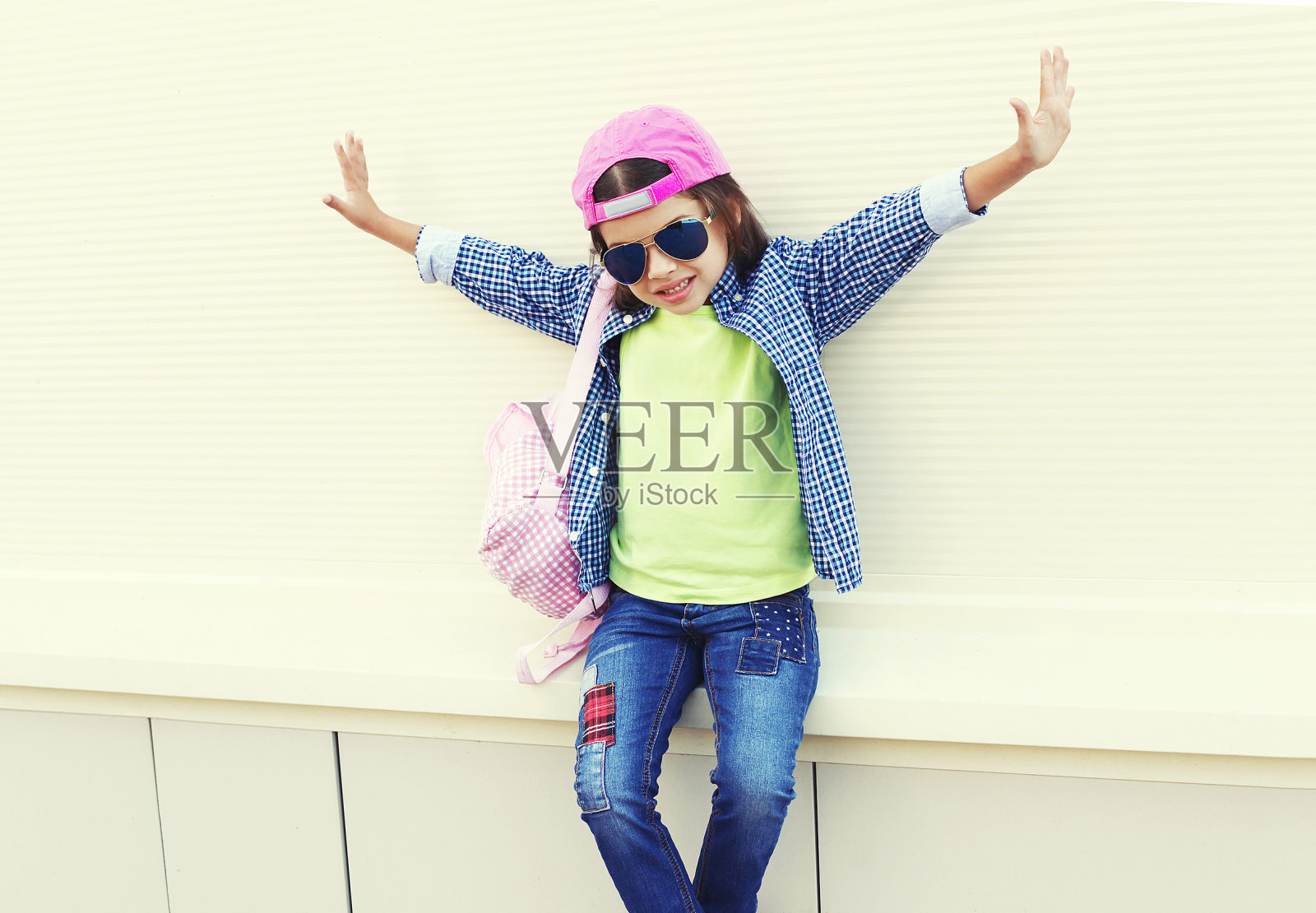 时尚的小女孩戴着太阳镜和棒球帽照片摄影图片