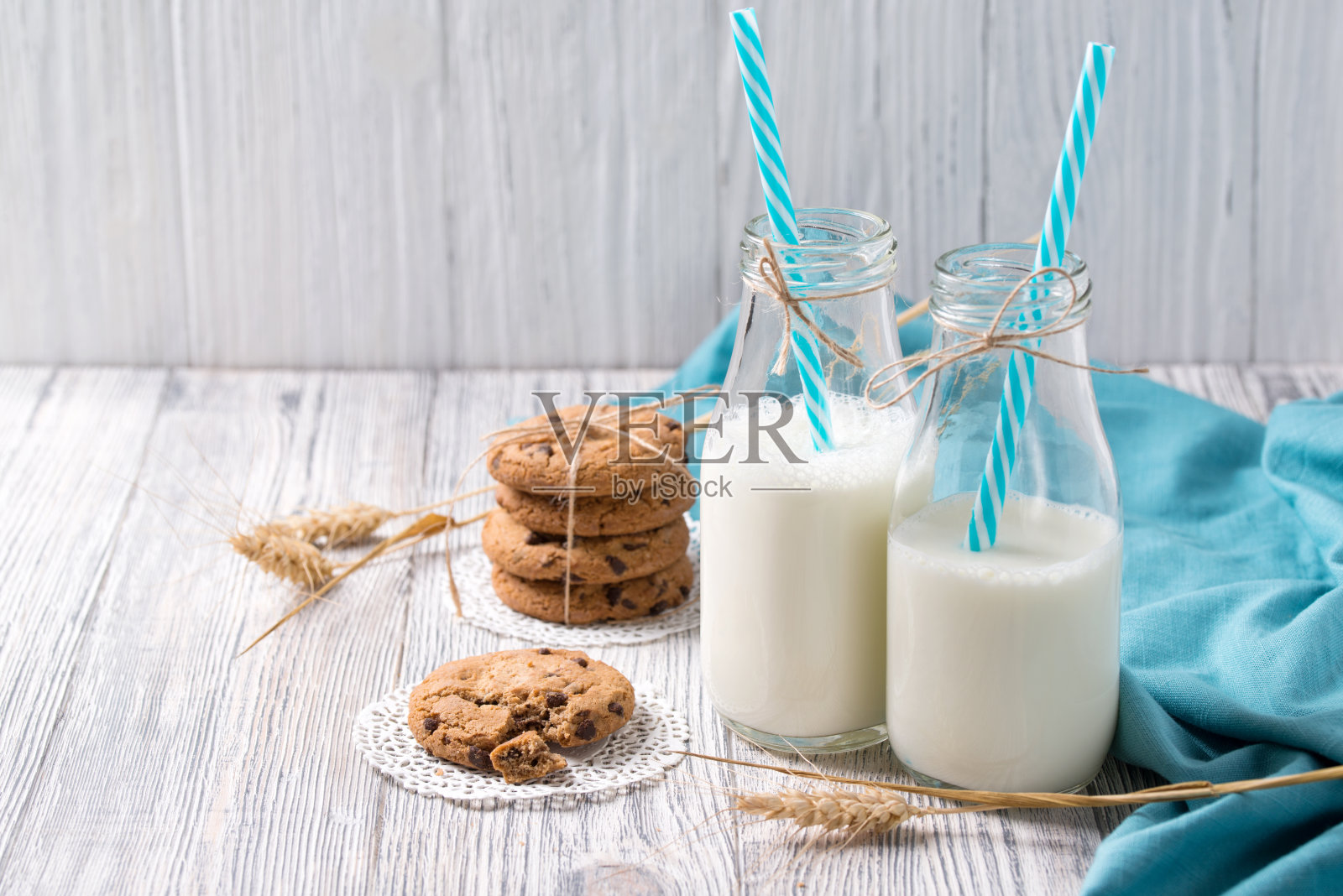 木制背景上放着牛奶和巧克力饼干照片摄影图片