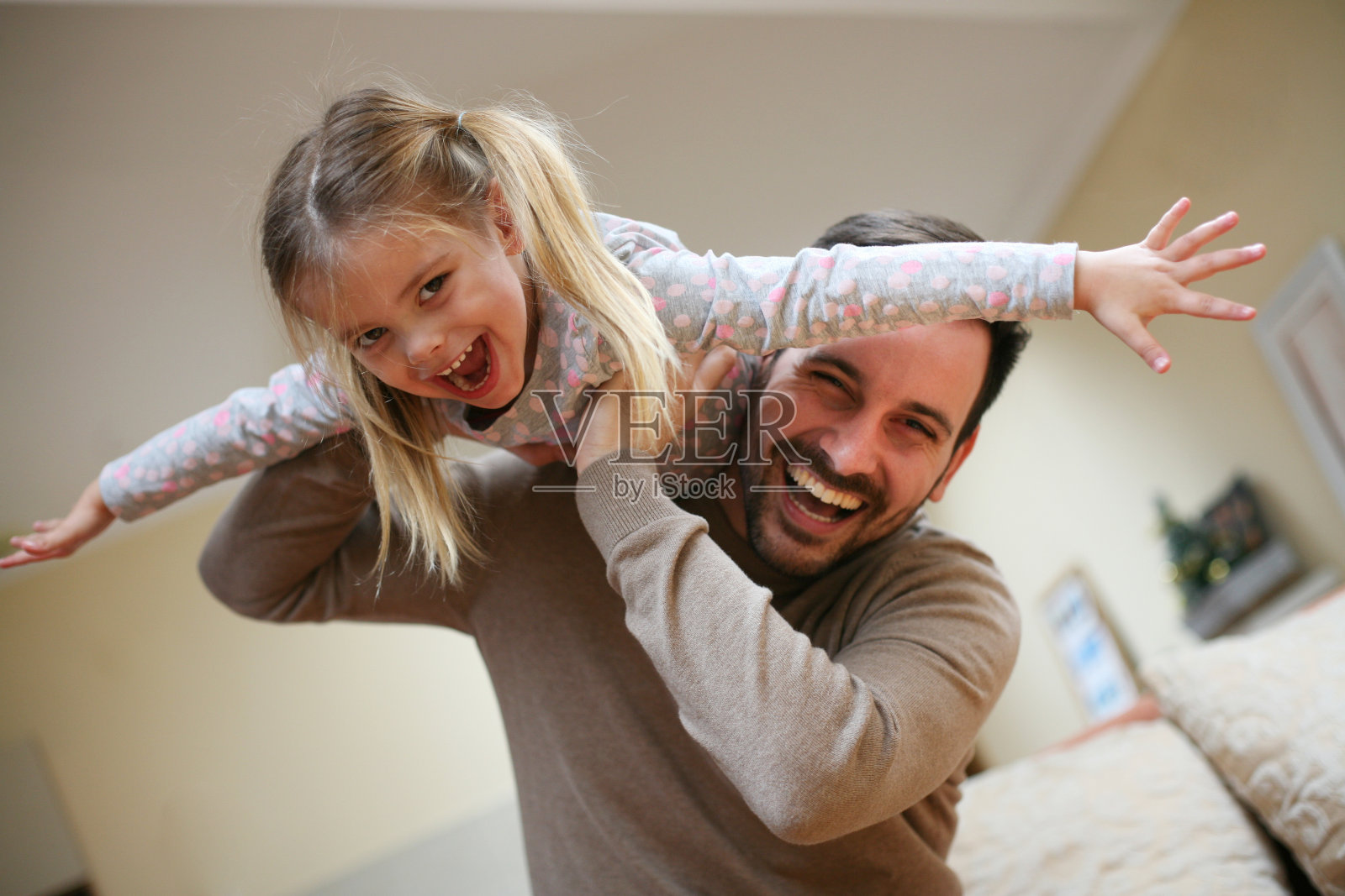 年轻的爸爸和可爱的女儿在家。照片摄影图片