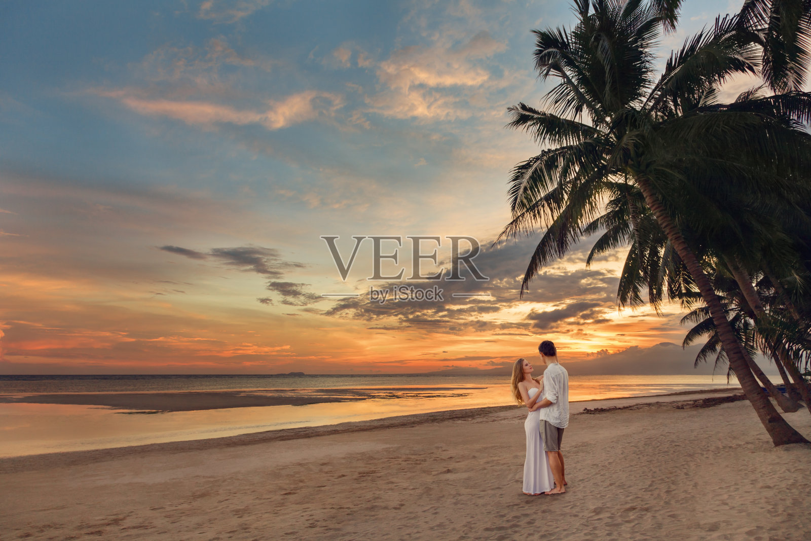 热带海滩上的一对年轻夫妇照片摄影图片