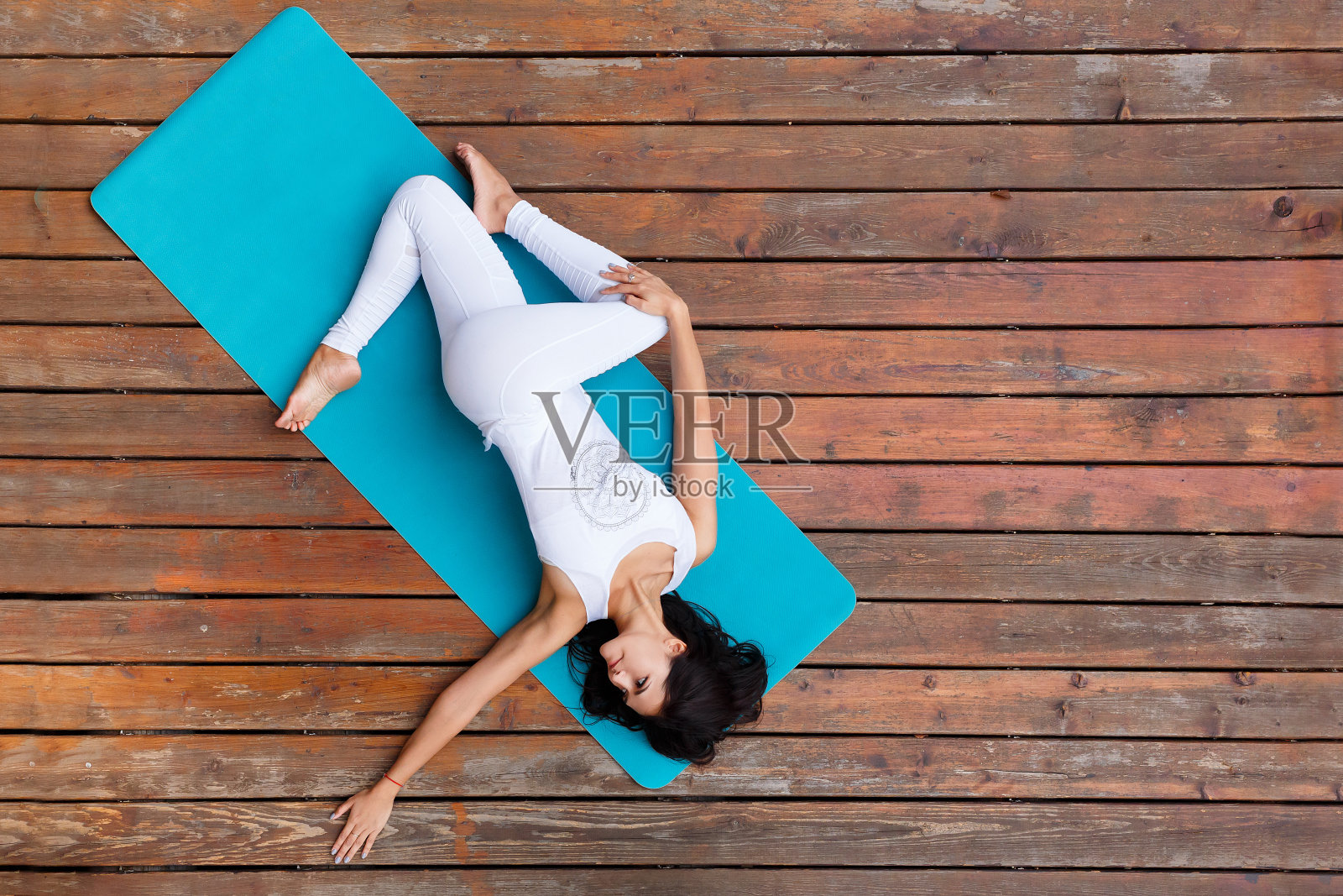 健身女性在木地板平台上锻炼，做瑜伽练习照片摄影图片