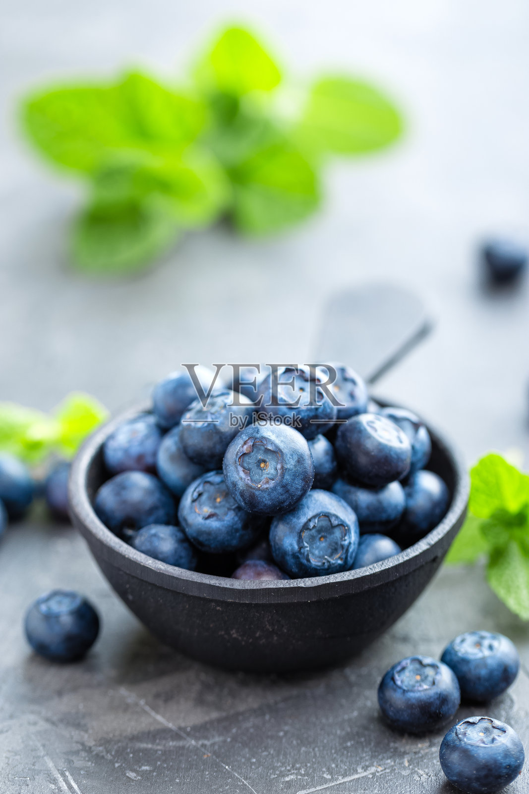 新鲜的蓝莓放在一个碗里，黑色背景，俯视图。多汁的野生森林浆果，越桔。健康的饮食和营养。照片摄影图片