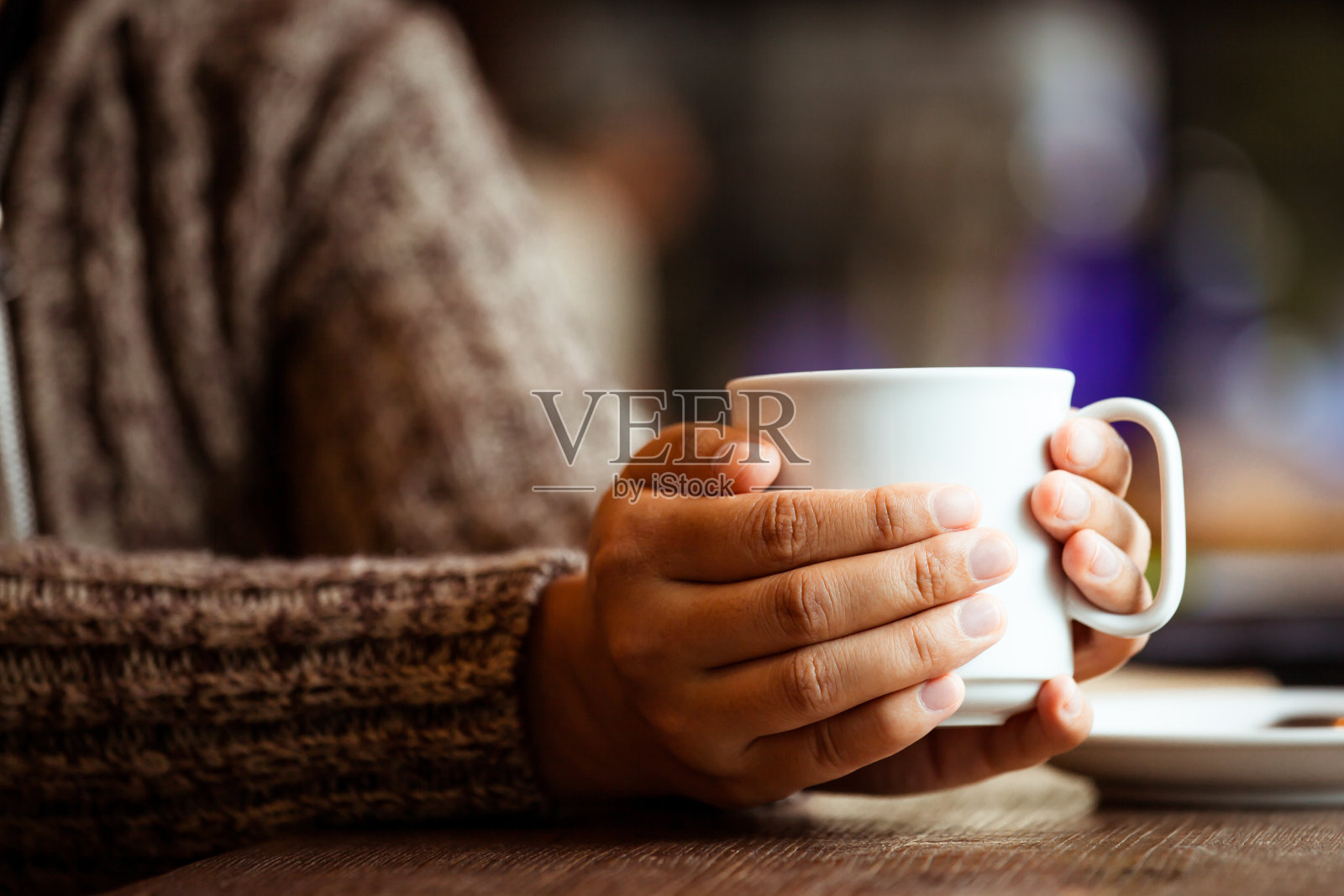 下雨天的咖啡馆里，女人手里拿着一杯咖啡或茶照片摄影图片