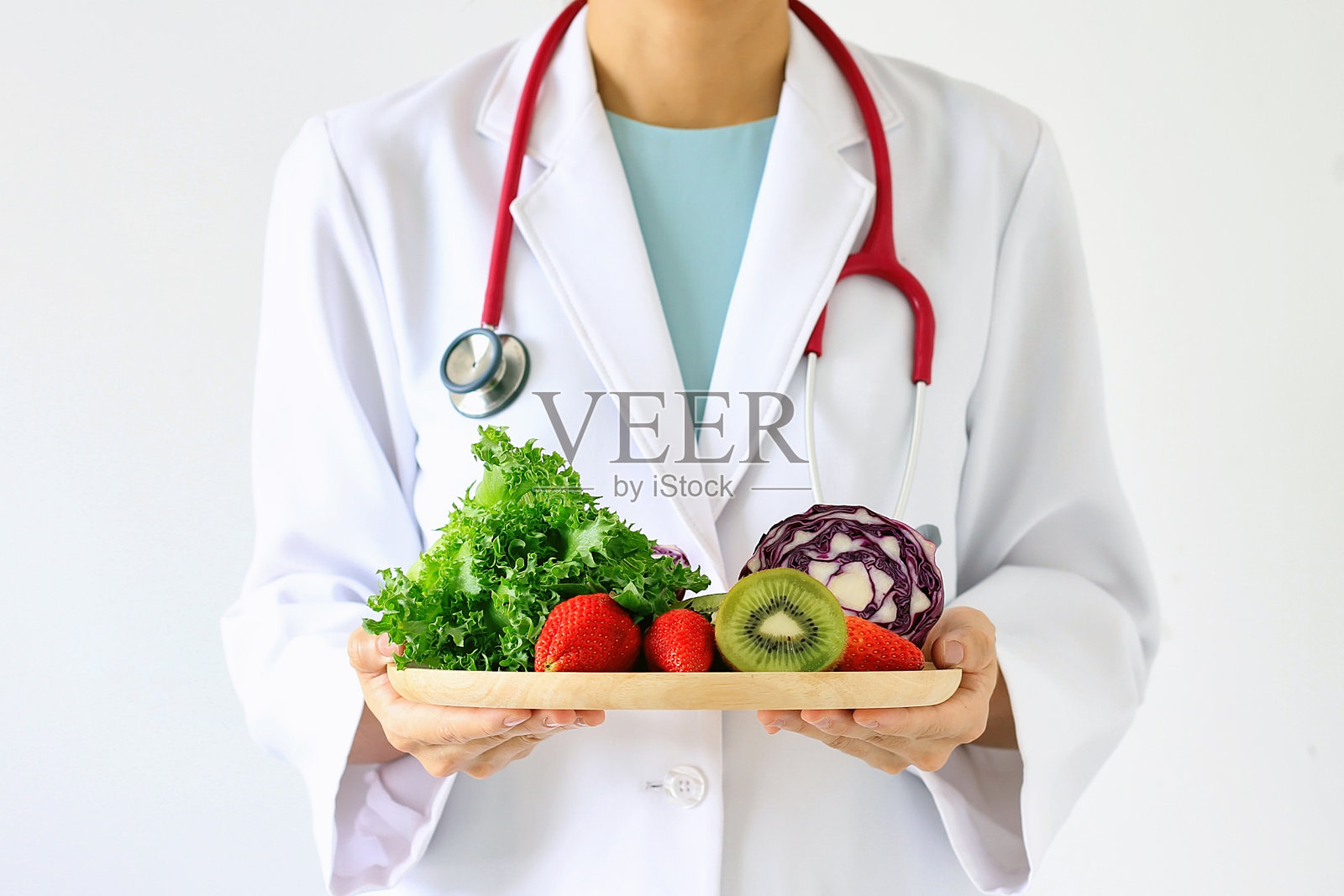 医生持新鲜水果和蔬菜，健康饮食，营养食品为良好的健康处方。照片摄影图片