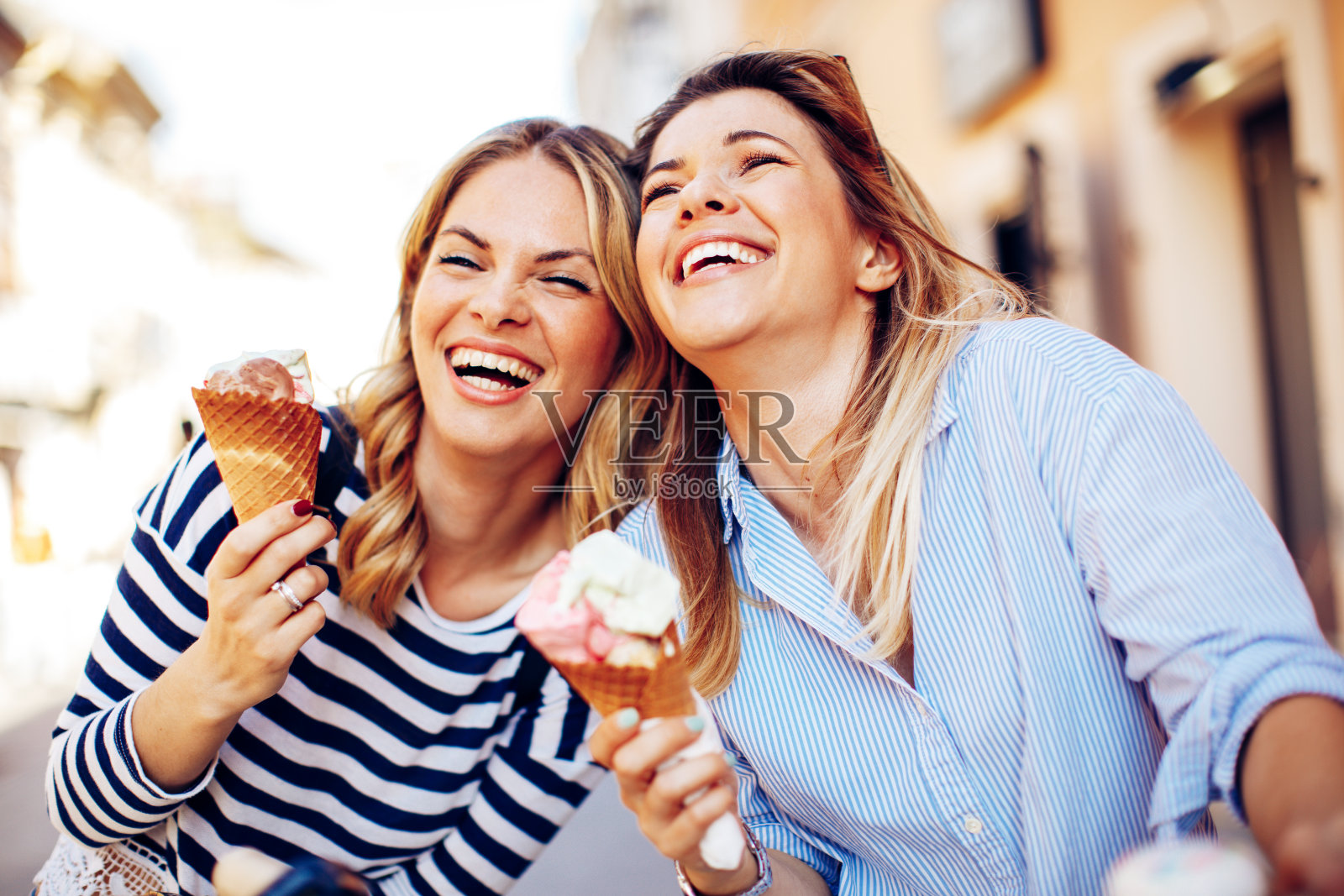 两个年轻的女人笑着手里拿着冰淇淋照片摄影图片